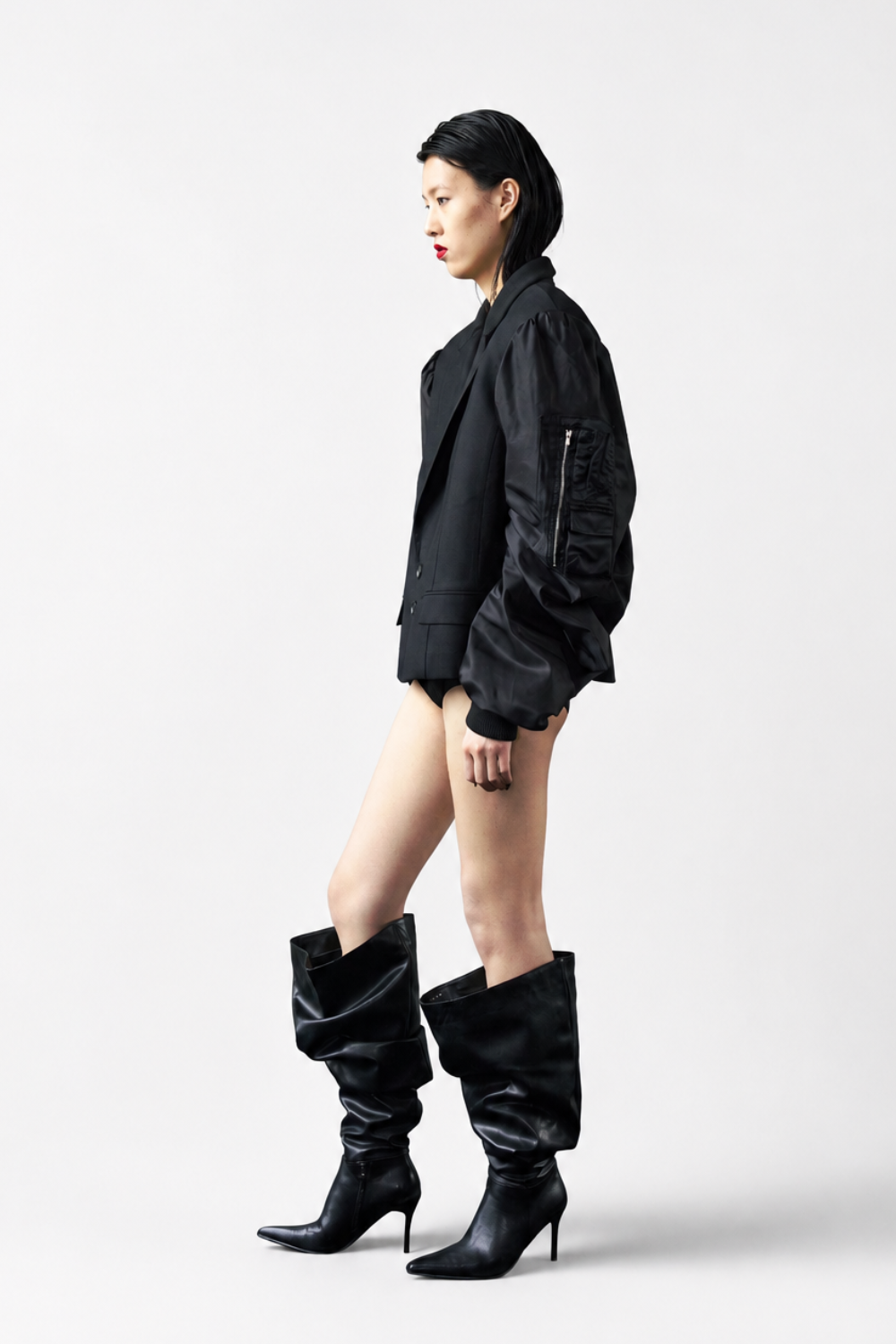 Model wearing the Hybrid Bomber Sleeve Blazer in black, featuring oversized bomber-style sleeves with zipper detailing, structured lapels, and sharp tailoring emphasizing a bold sculptural silhouette.