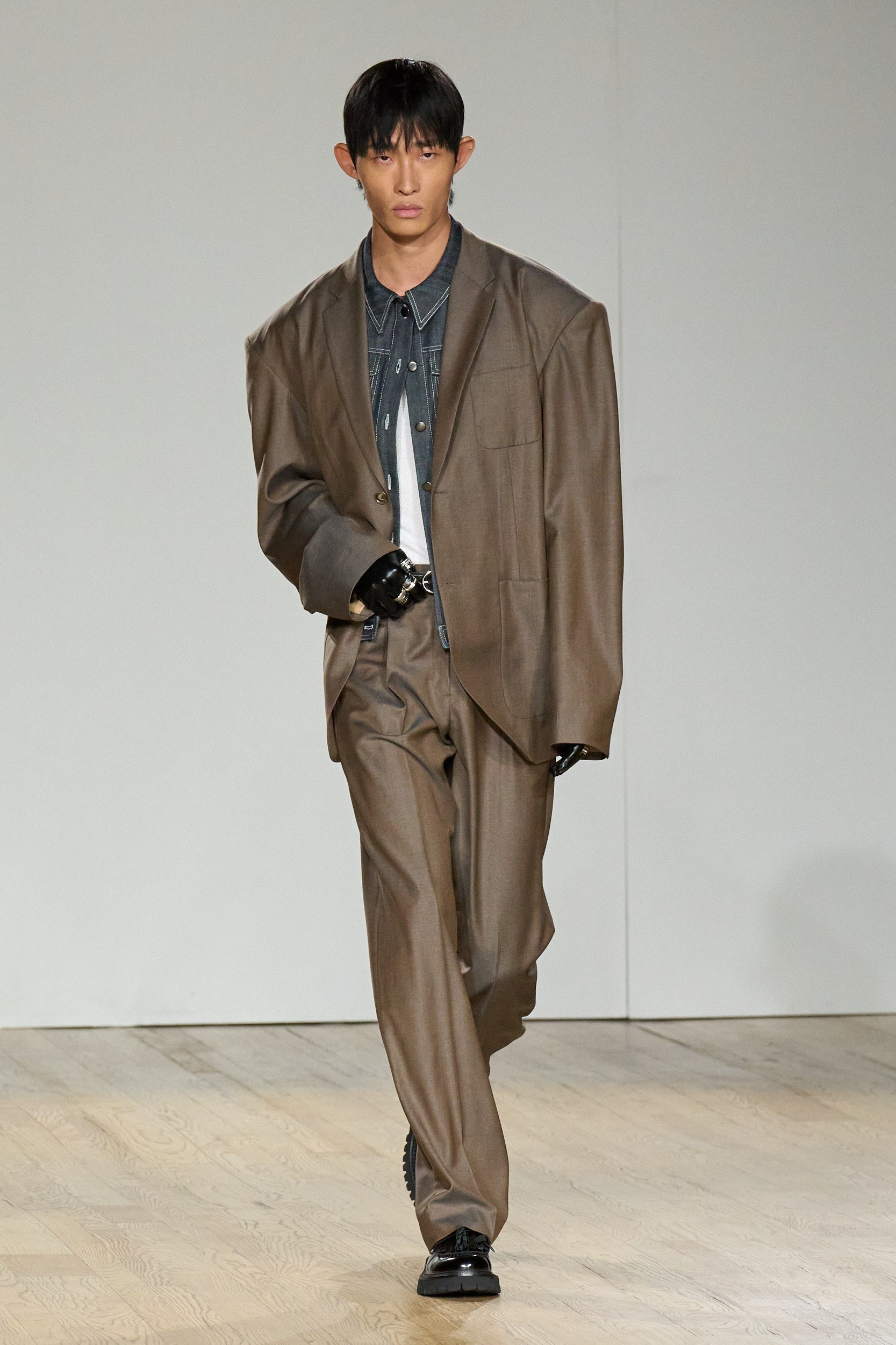 Front view of Taupe Pleated Wide-Leg Trousers paired with an oversized blazer and dark shirt, featuring a relaxed fit and sharp pleats that highlight bespoke SHAO New York tailoring and luxury designer fashion.