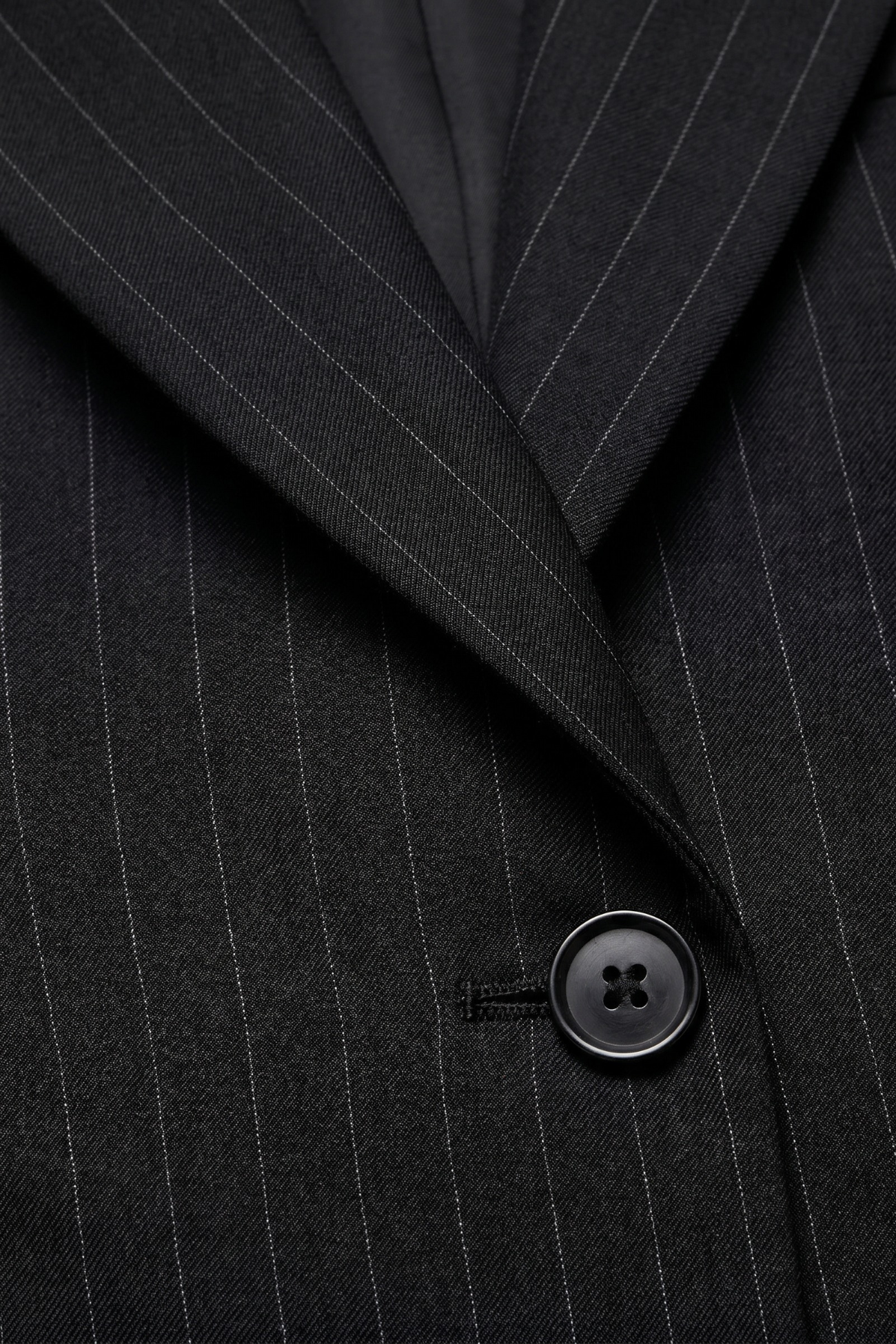 Close-up of Black Pinstripe Boxy Oversized Jacket showing fine vertical stripes, tailored lapel, and single black button, embodying SHAO New York bespoke tailoring and luxury designer fashion.