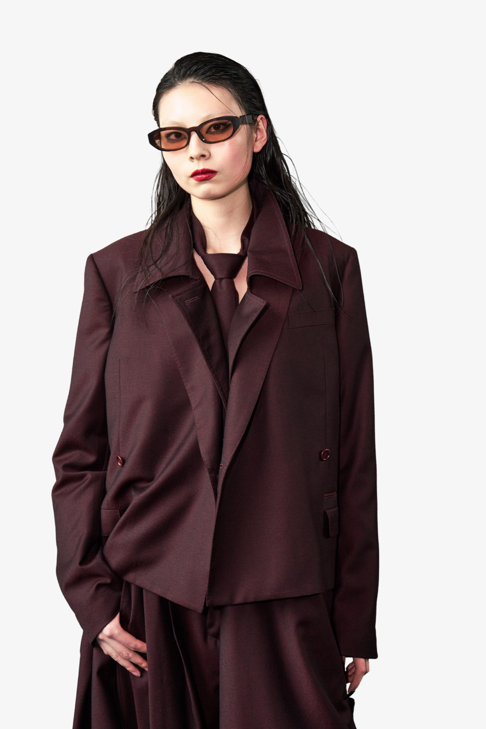 Model wearing a deep plum tailored blazer and pants with a Wool Tie 7.5 cm in matching rich plum, styled with sleek hair and tinted sunglasses, showcasing SHAO New York bespoke tailoring and refined luxury designer fashion.