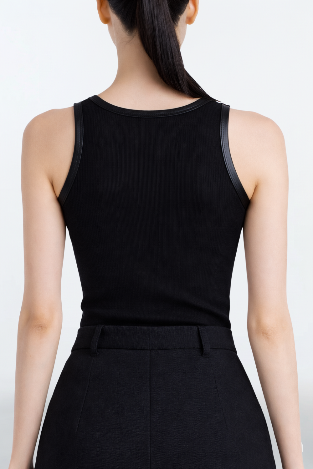 Black Rib-Knit Tank Top with Leather Trim showcasing a sleek ribbed fabric and subtle leather edging along the neckline and armholes, reflecting SHAO New York’s luxury designer fashion and sculptural silhouette.