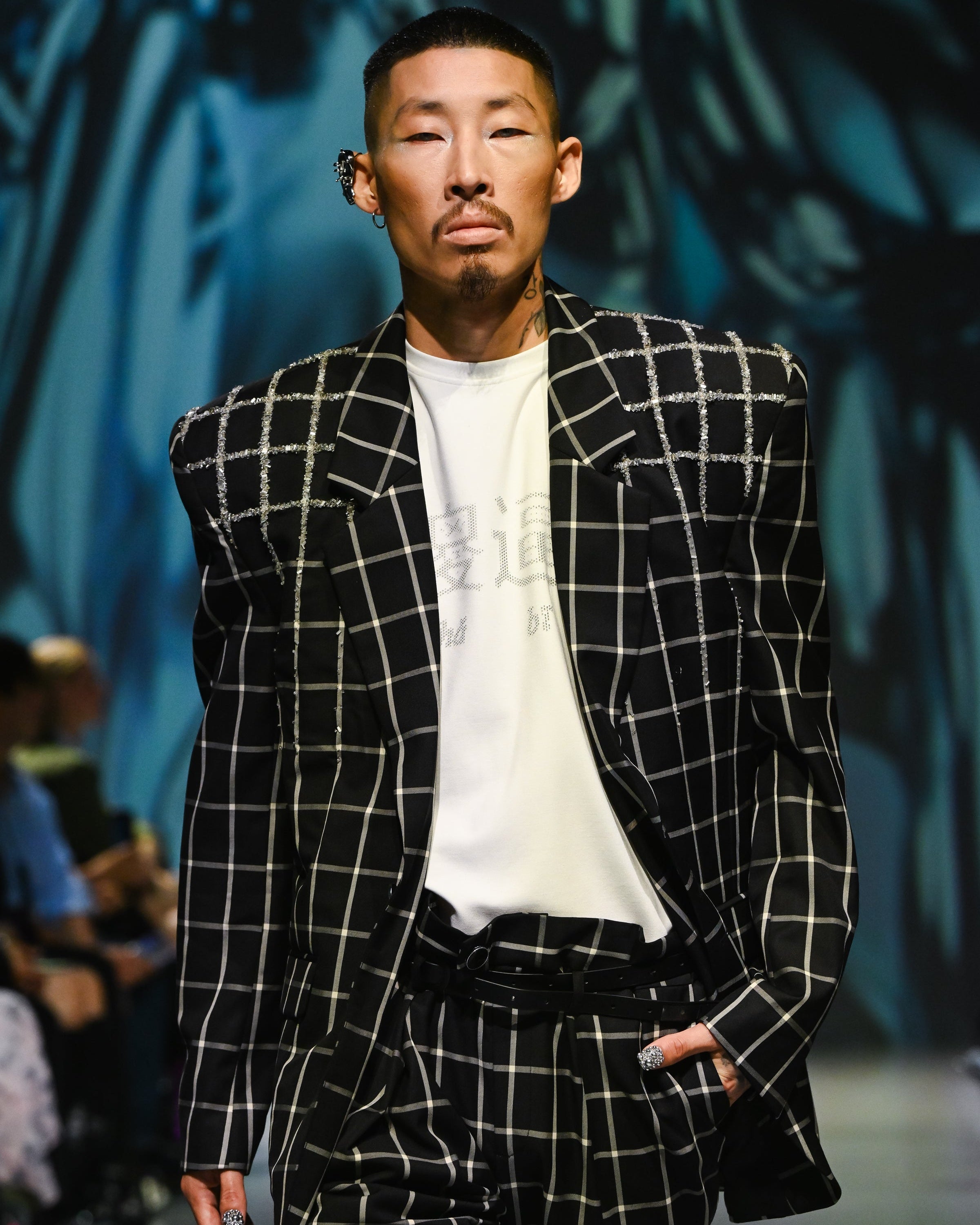 Model wearing a Black Windowpane Tailored Blazer with sharply structured shoulders and mixed windowpane patterns, paired with matching trousers and a relaxed white shirt, showcasing bespoke New York designer tailoring.