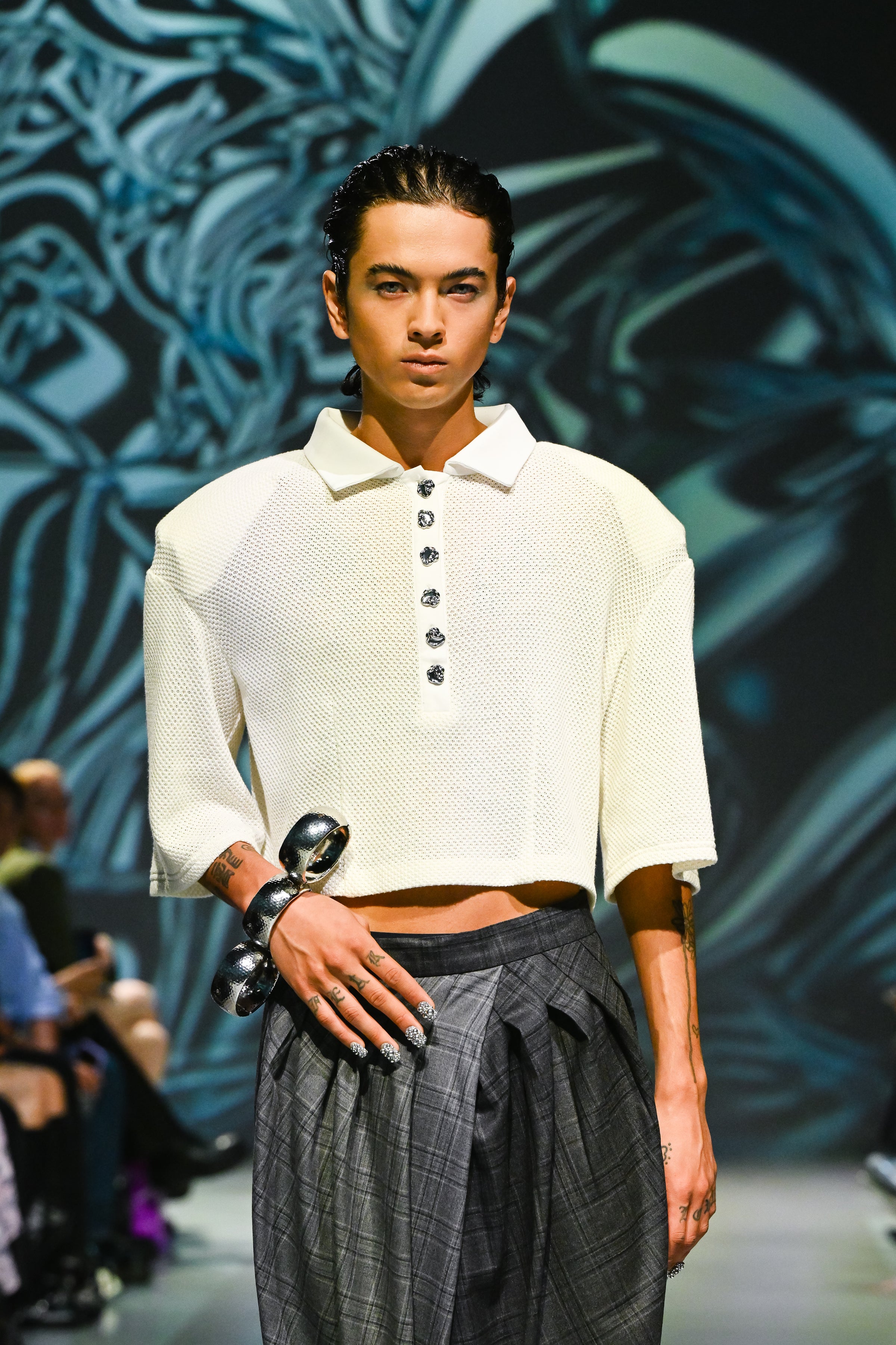 Model wearing Gray Check Wide-Leg Pleated Trousers with a subtle check pattern and deep pleats, paired with a textured cropped polo top, showcasing SHAO New York luxury designer fashion featuring a sculptural silhouette.