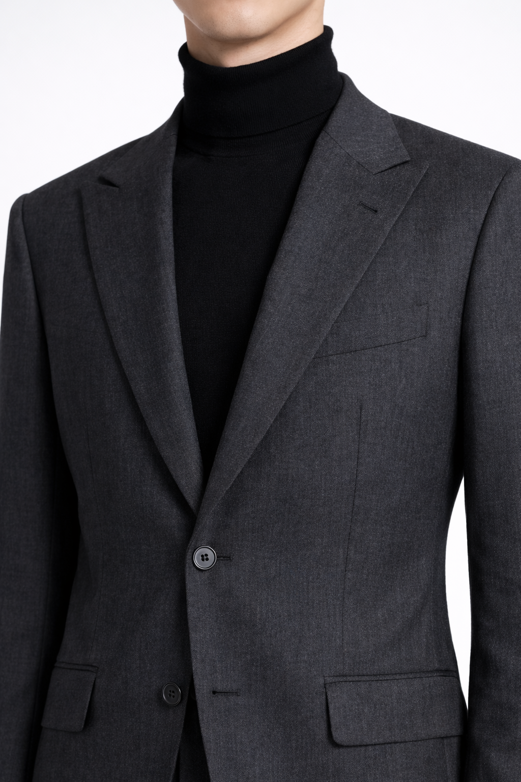 Close-up of a Charcoal Grey Relaxed Fit Two Piece Suit jacket featuring a single-button closure, notch lapels, and clean tailored lines, styled with a black turtleneck, exemplifying SHAO New York bespoke tailoring and a modern sculptural silhouette.