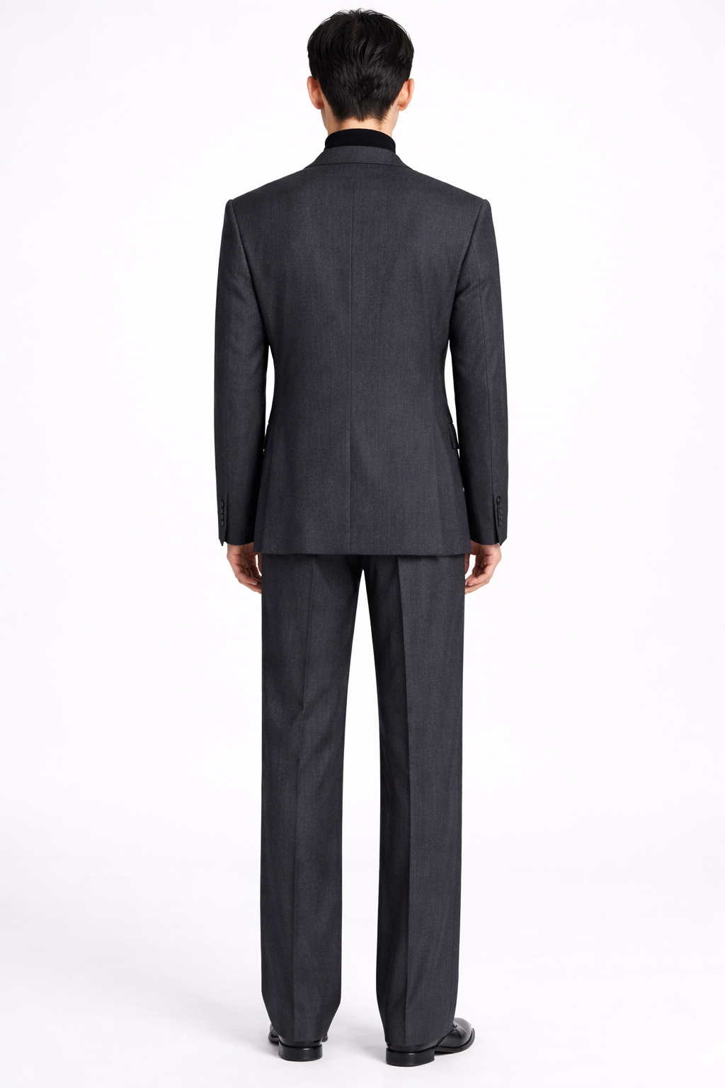 Back view of a model wearing the Charcoal Grey Relaxed Fit Jacket with matching tailored trousers, showcasing a clean, elongated silhouette and refined bespoke detailing from SHAO New York.