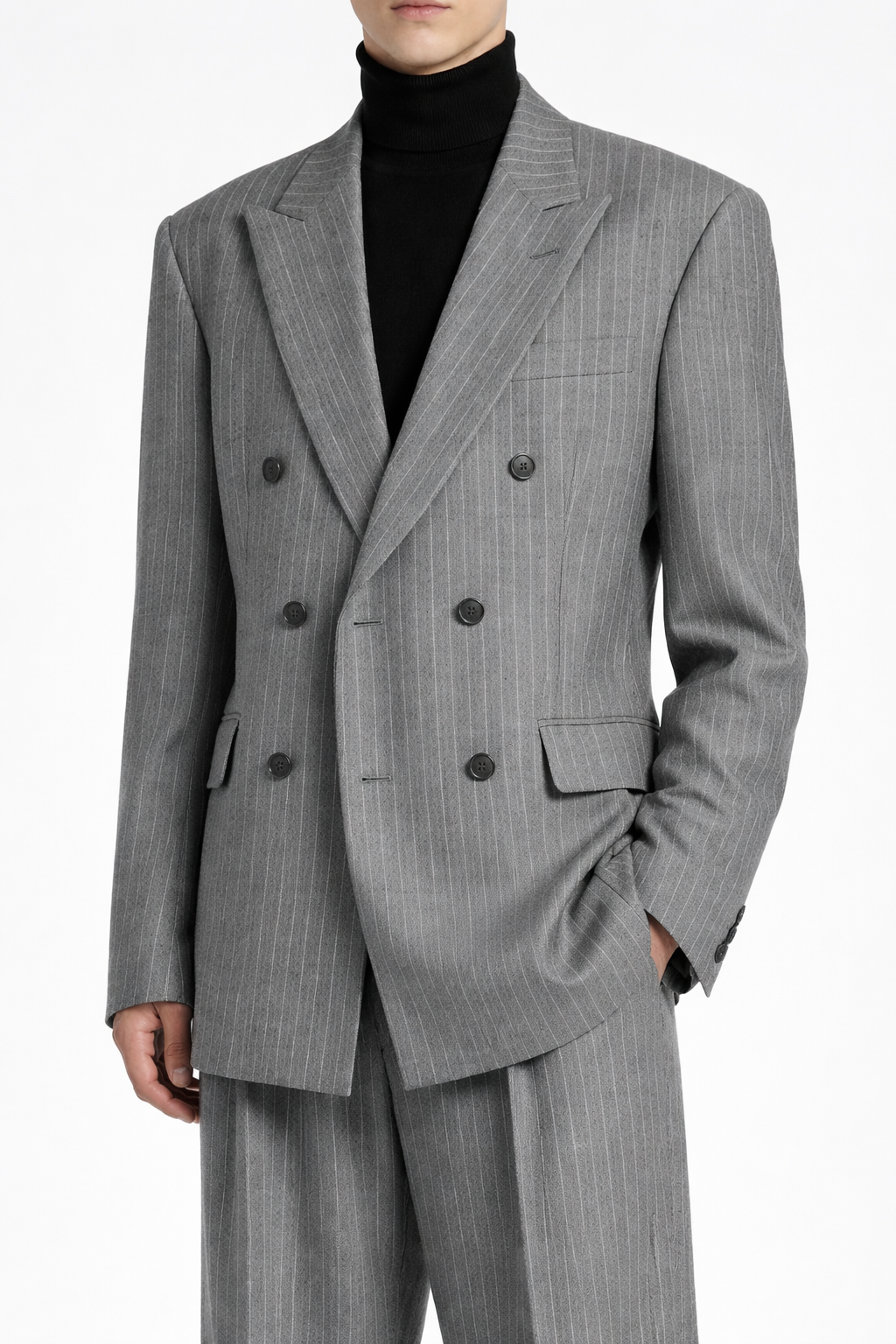 Model wearing a Grey Pinstripe Boxy Double Breasted Blazer with structured shoulders, wide lapels, and fine vertical pinstripes, highlighting bespoke tailoring and a sculptural silhouette.