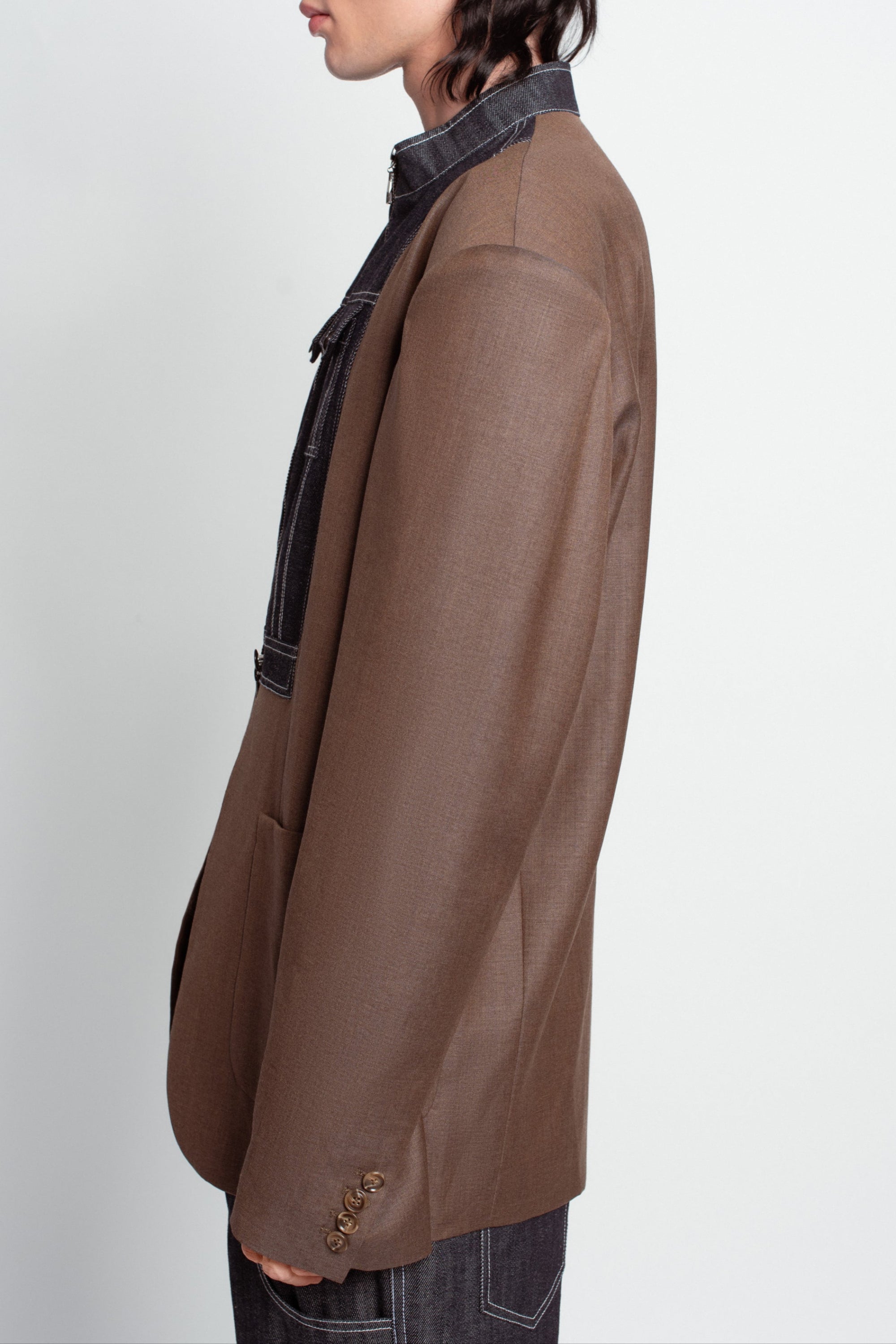 Side profile of Warm Brown Oversized Blazer – Exposed Denim Dickie Detail, featuring structured shoulders and layered denim accents for a modern luxury designer fashion look with bespoke New York tailoring.