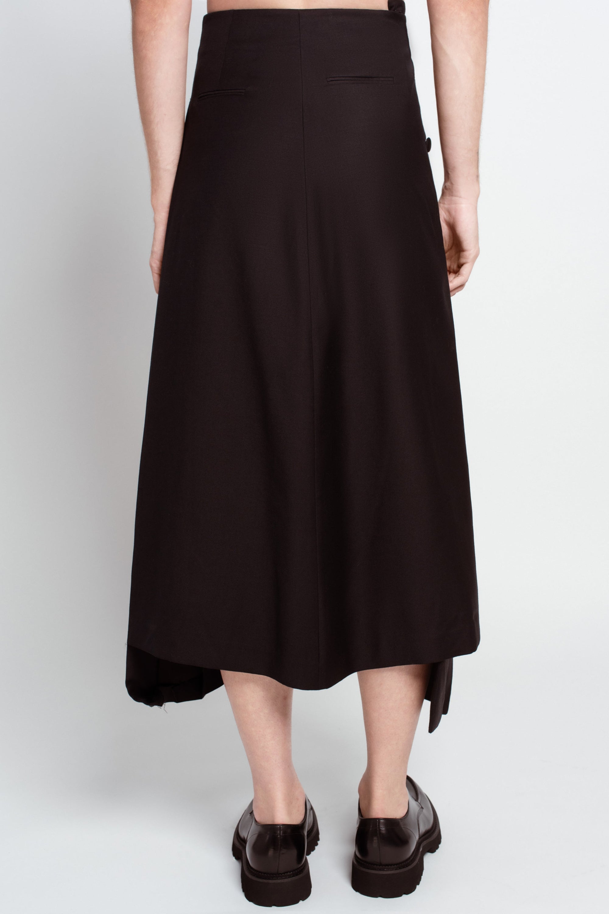 Rear view of Jet Black Wool Wrap Skirt – Pleated Long Silhouette displaying a clean, tailored back with subtle pocket detailing and a smooth drape that highlights SHAO New York bespoke tailoring and luxury designer fashion.