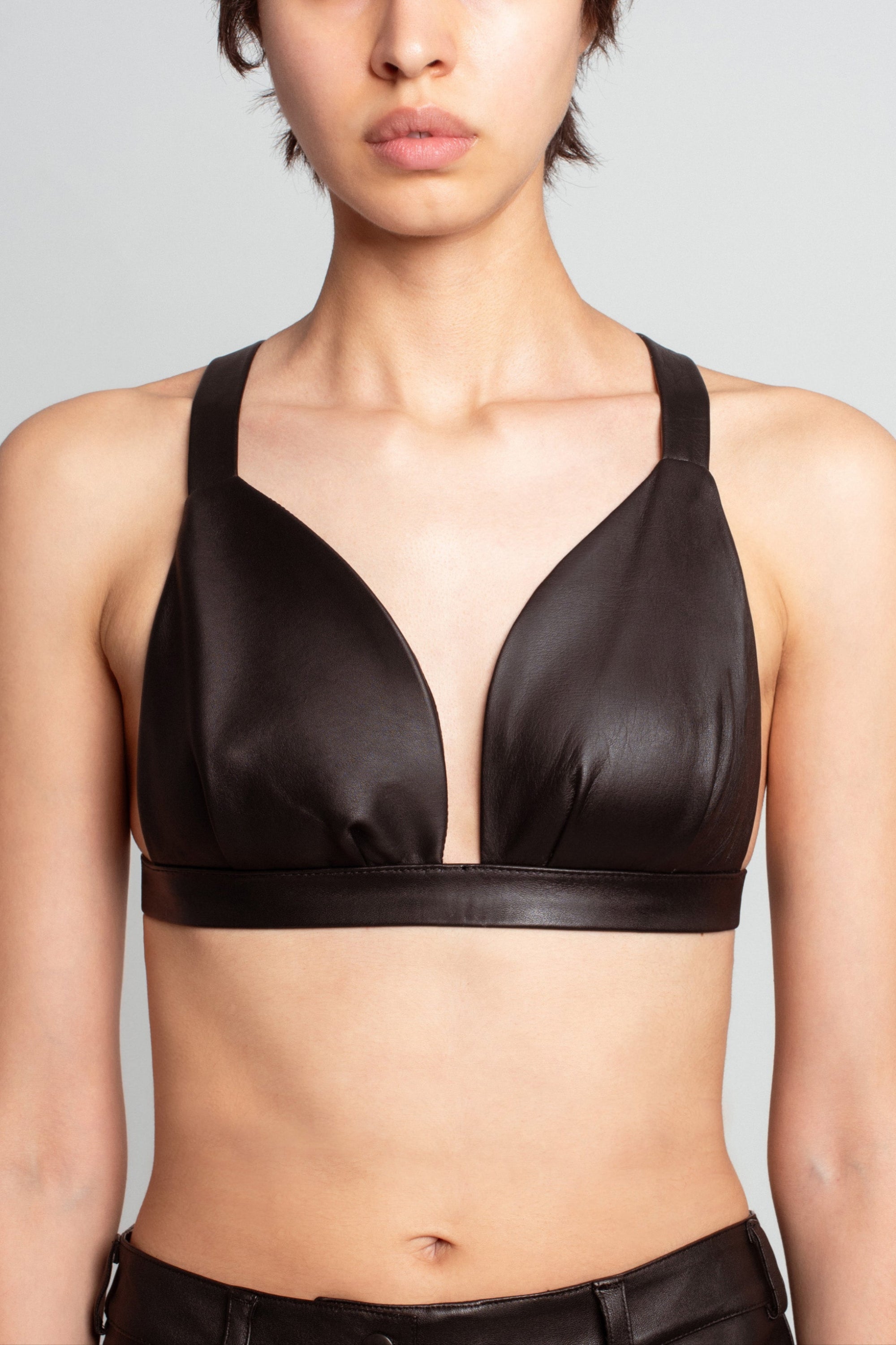 Front view of Jet Black Leather Bustier – Architectural Construction featuring wide shoulder straps and a plunging neckline, crafted for a sleek sculptural luxury designer fashion look.