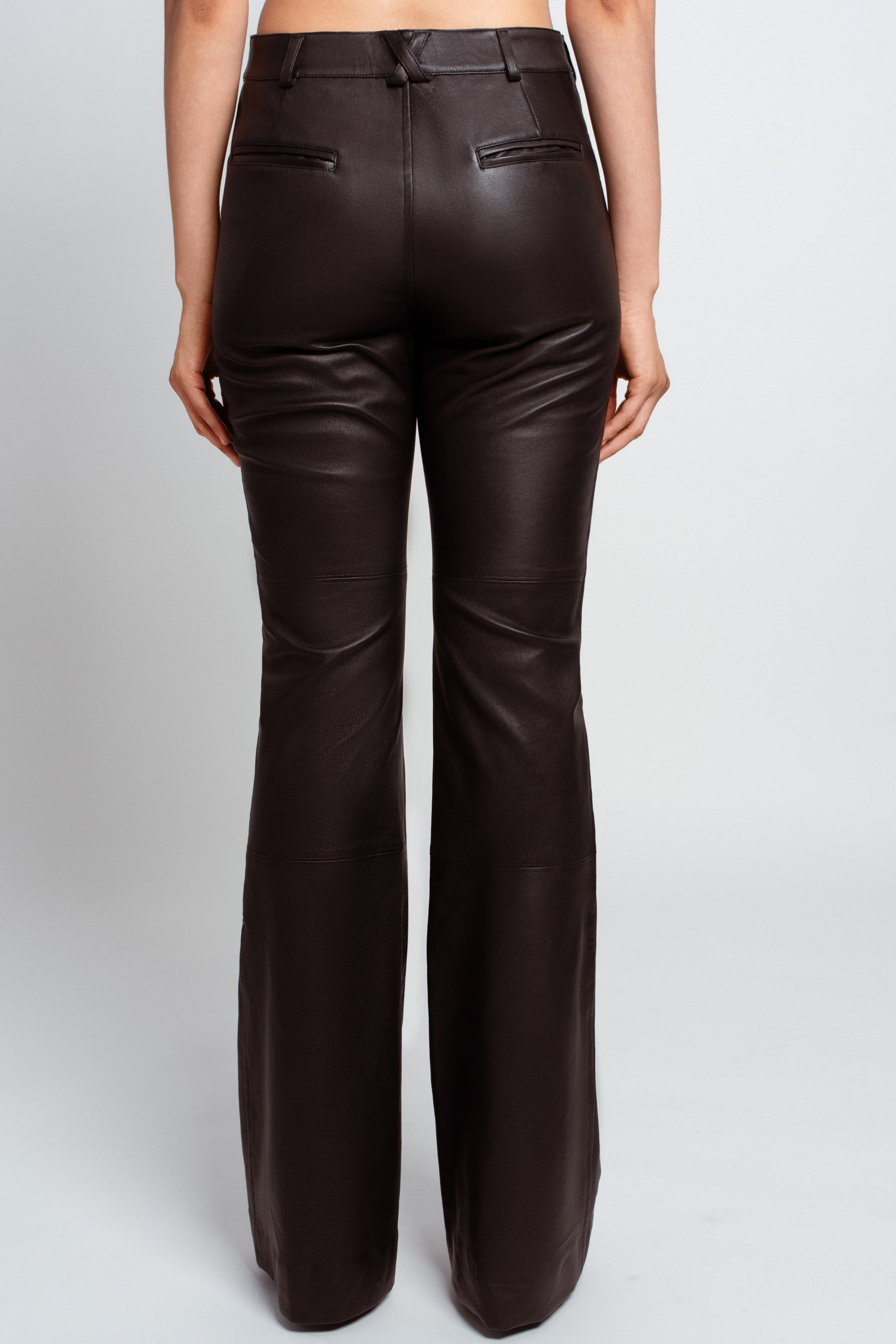 Back view of Jet Black Leather Flared Trousers – Contemporary Silhouette featuring tailored back pockets, sleek smooth leather, and a flared leg cut embodying luxury designer fashion and New York bespoke tailoring.