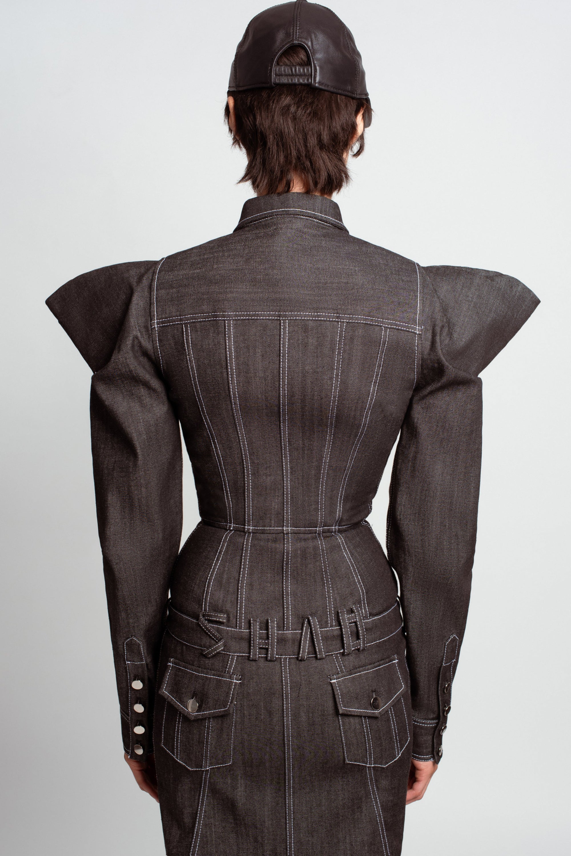 Back view of Midnight Blue Sculptural Denim Dress – Architectural Puff Shoulders, featuring sharply structured puffed shoulders, tailored seams, and a cinched waist for a sculptural silhouette in luxury designer fashion.