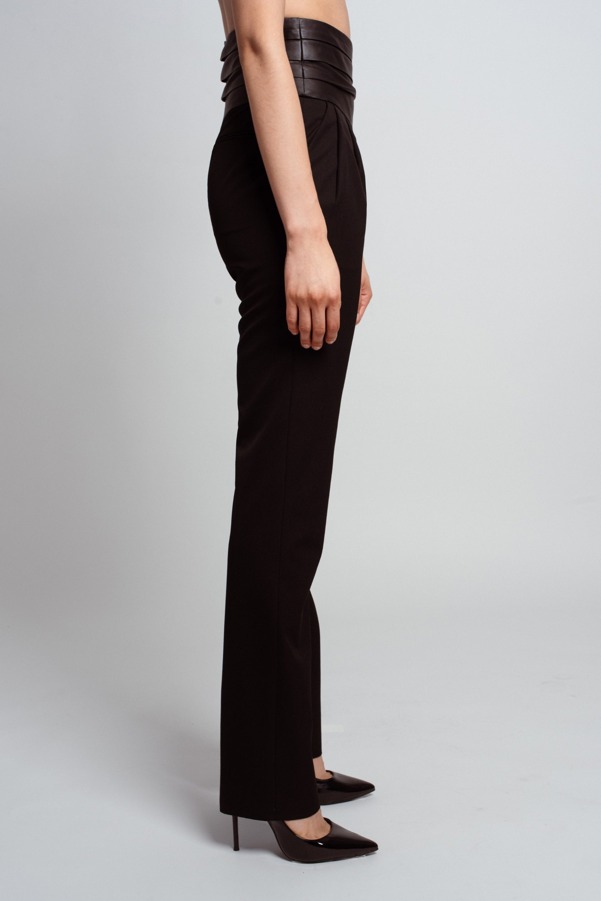 Side view of Jet Black Tailored Trousers – Leather Cummerbund Detail highlighting a sleek, high-waisted fit with sculptural tailoring and a refined silhouette in luxury designer fashion by SHAO New York.
