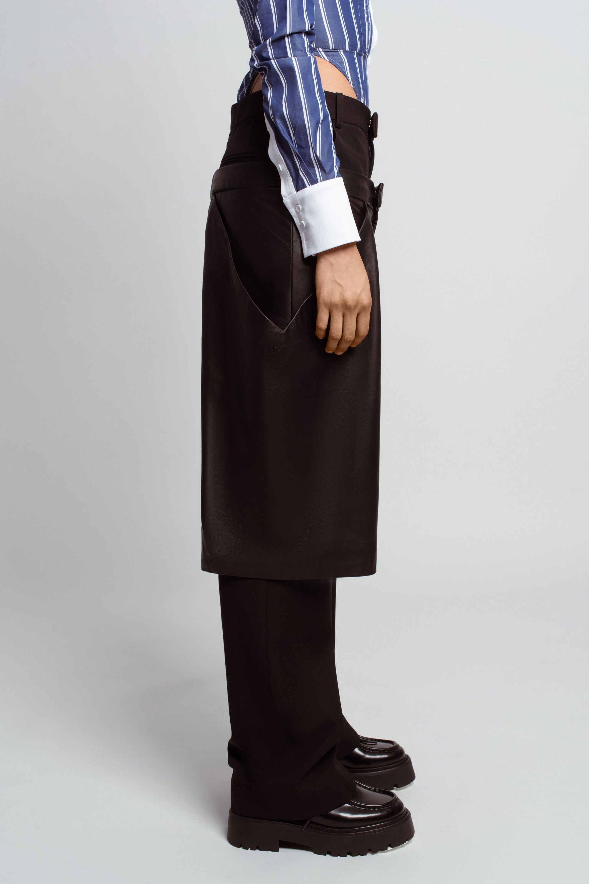 Side profile of Black Straightleg Wool Trousers with Boxy Leather Shorts Overlay – featuring tailored pockets, a structured leather overlay, and a sleek silhouette showcasing luxury designer fashion and bespoke New York tailoring.