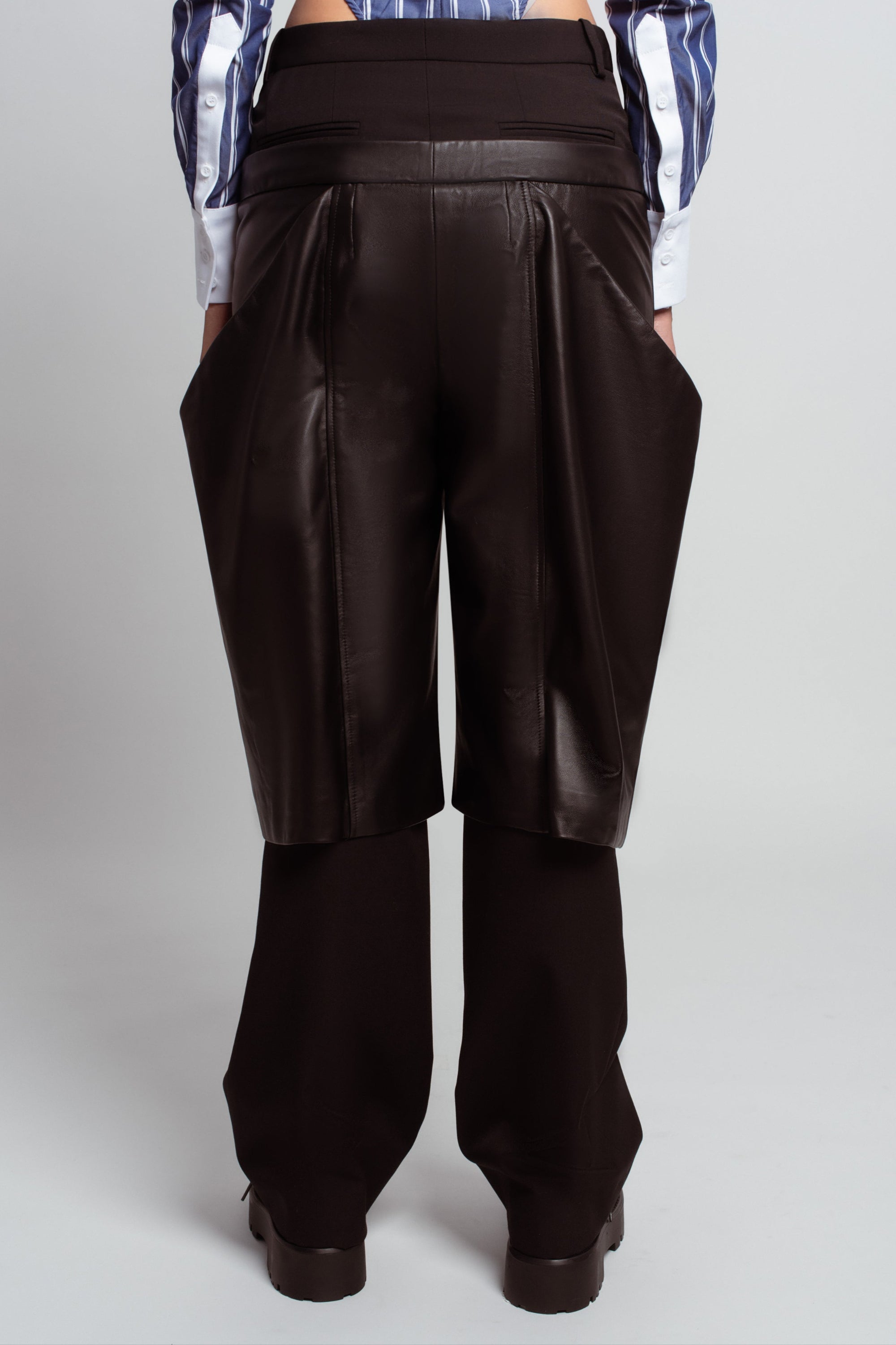 Rear view of Black Straightleg Wool Trousers with Boxy Leather Shorts Overlay, featuring a high-waist band, sculptural leather overlay, and tailored straight-leg fit in luxury designer fashion.