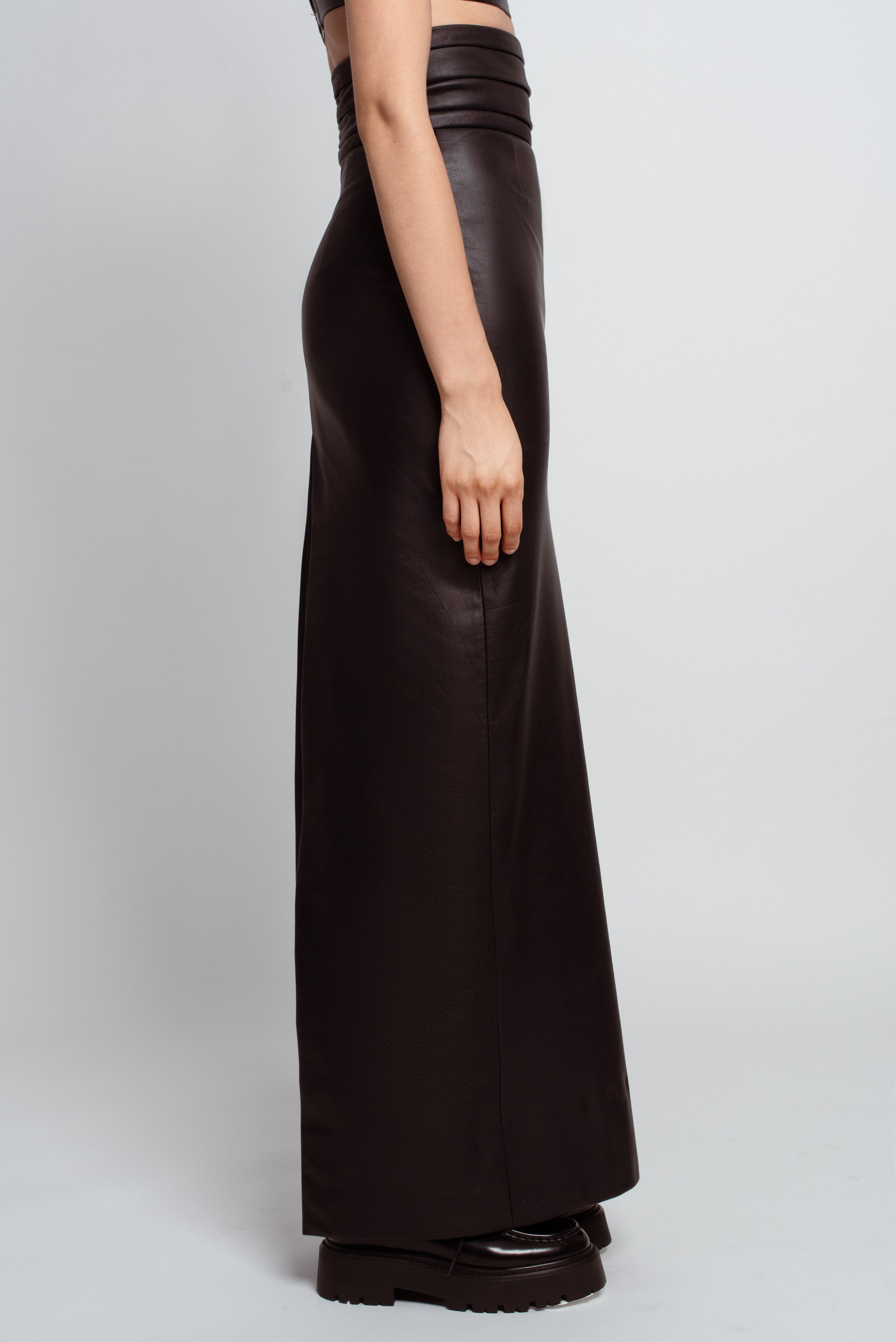 Side view of Jet Black Leather Column Skirt – Cummerbund Detail featuring a sleek high waist and sculptural silhouette in luxury designer fashion and bespoke New York tailoring.