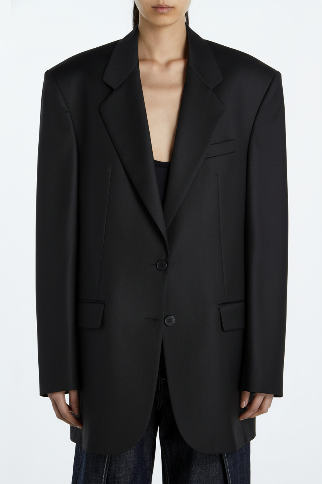Front-facing view of a Black Oversized Blazer – Architectural Boxy Silhouette with exaggerated shoulders, a sharp lapel, and structured tailoring, highlighting a modern sculptural silhouette in luxury designer fashion.
