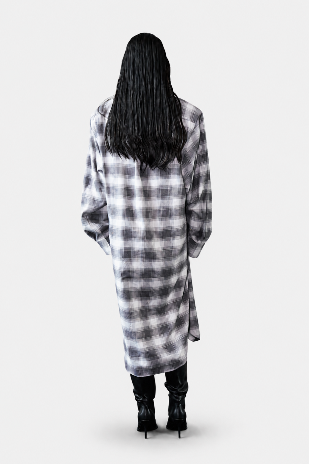 Back view of model wearing the Oversized Flannel Shirt Dress in soft gray plaid, featuring a relaxed long silhouette paired with black heeled boots for a refined casual look.