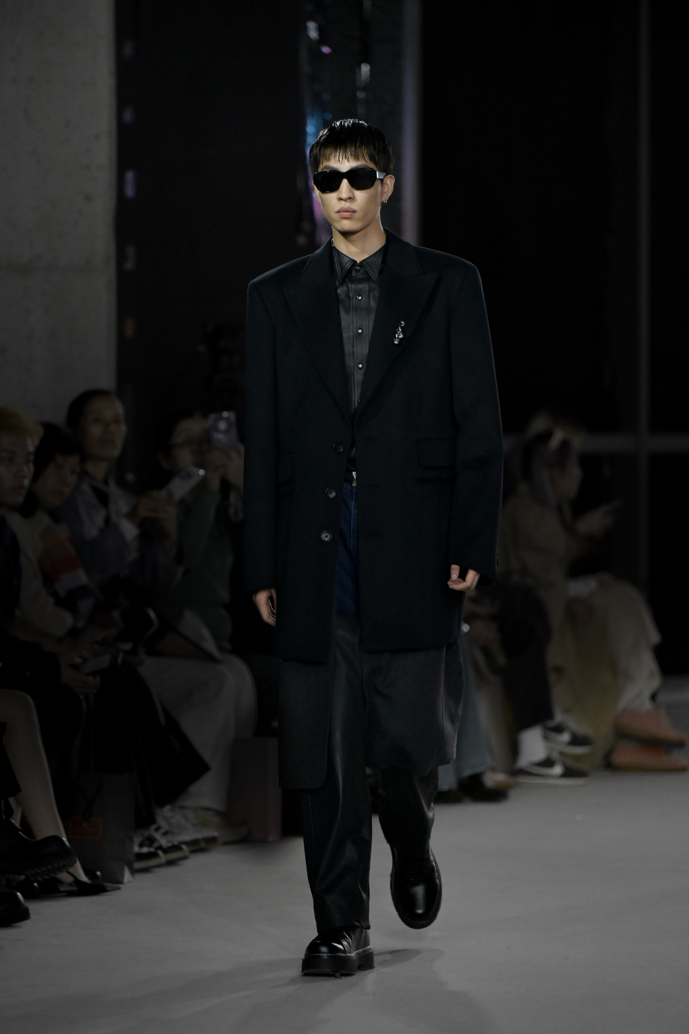 Model walking runway wearing the Cashmere Silk Double Layered Coat in black, featuring an oversized tailored silhouette, sharp lapels, and sleek layering, embodying SHAO New York bespoke tailoring and luxury designer fashion.