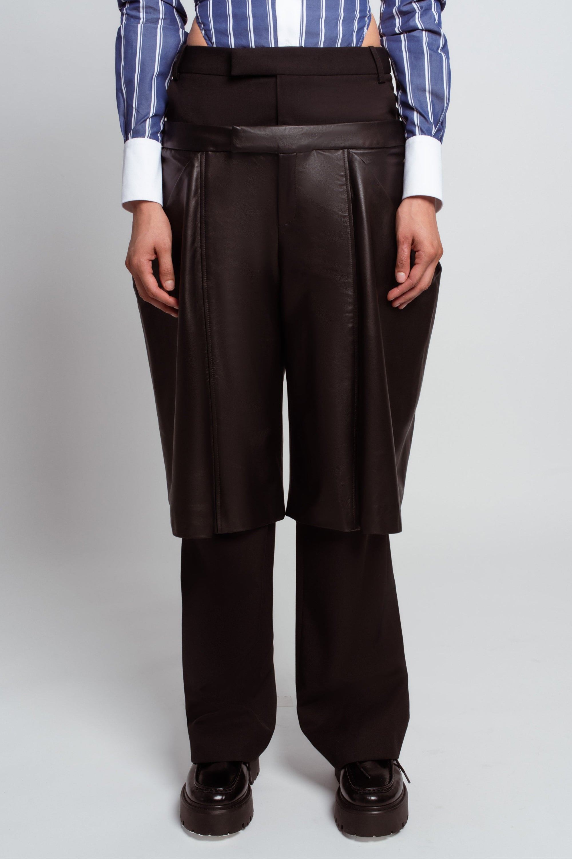 Black wool trousers with boxy leather overlay back view