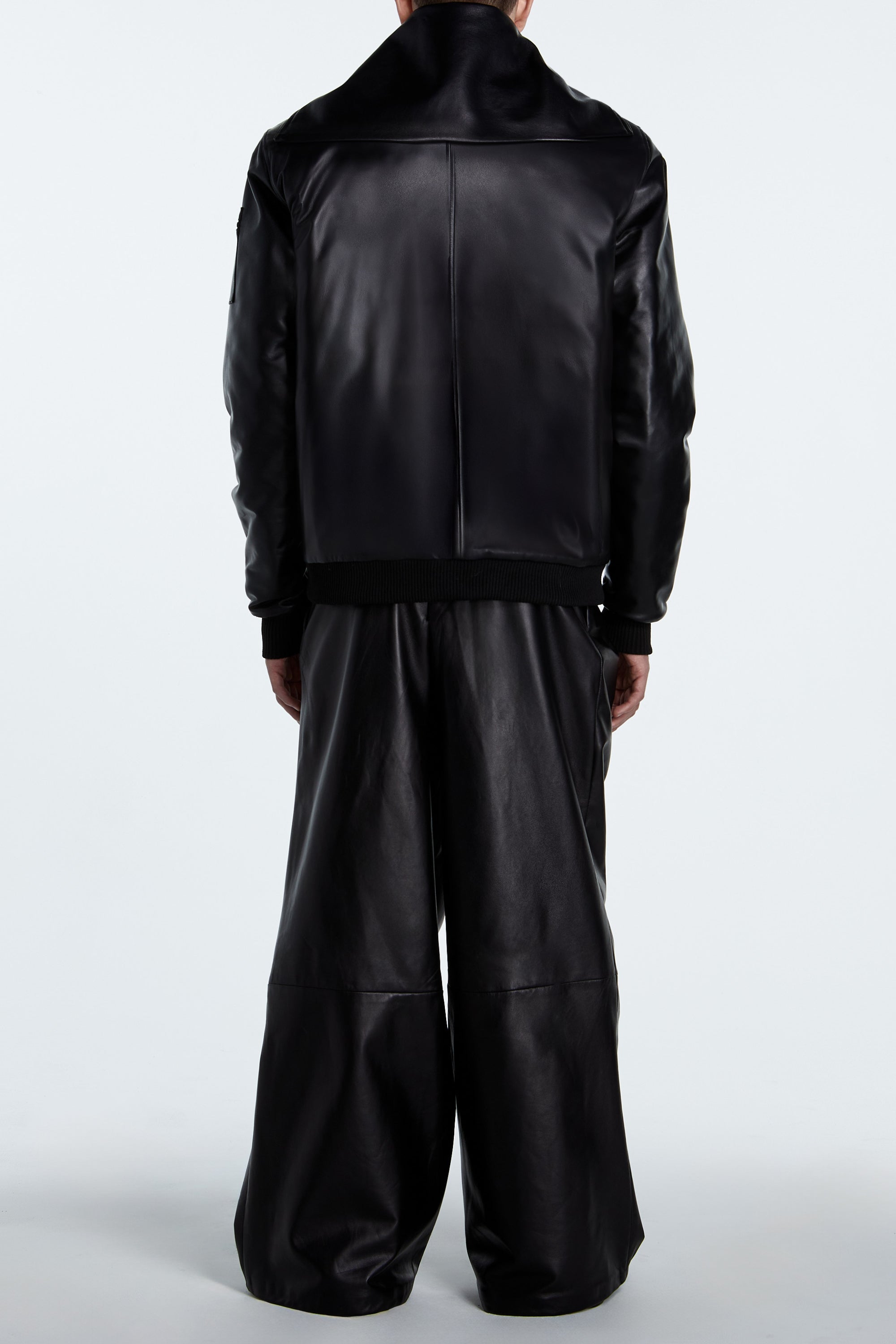 SHAO jet black leather asymmetrical pleated trousers back view