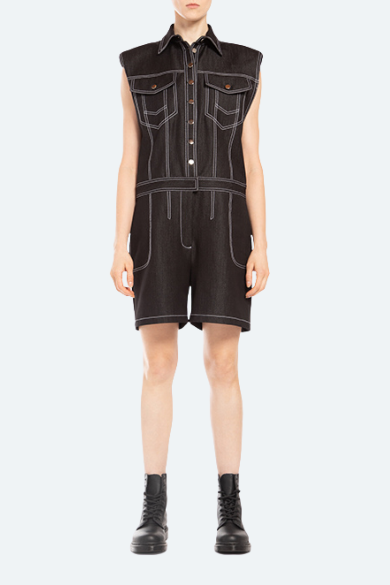 Front view of black denim romper with contrast stitching and flap pockets