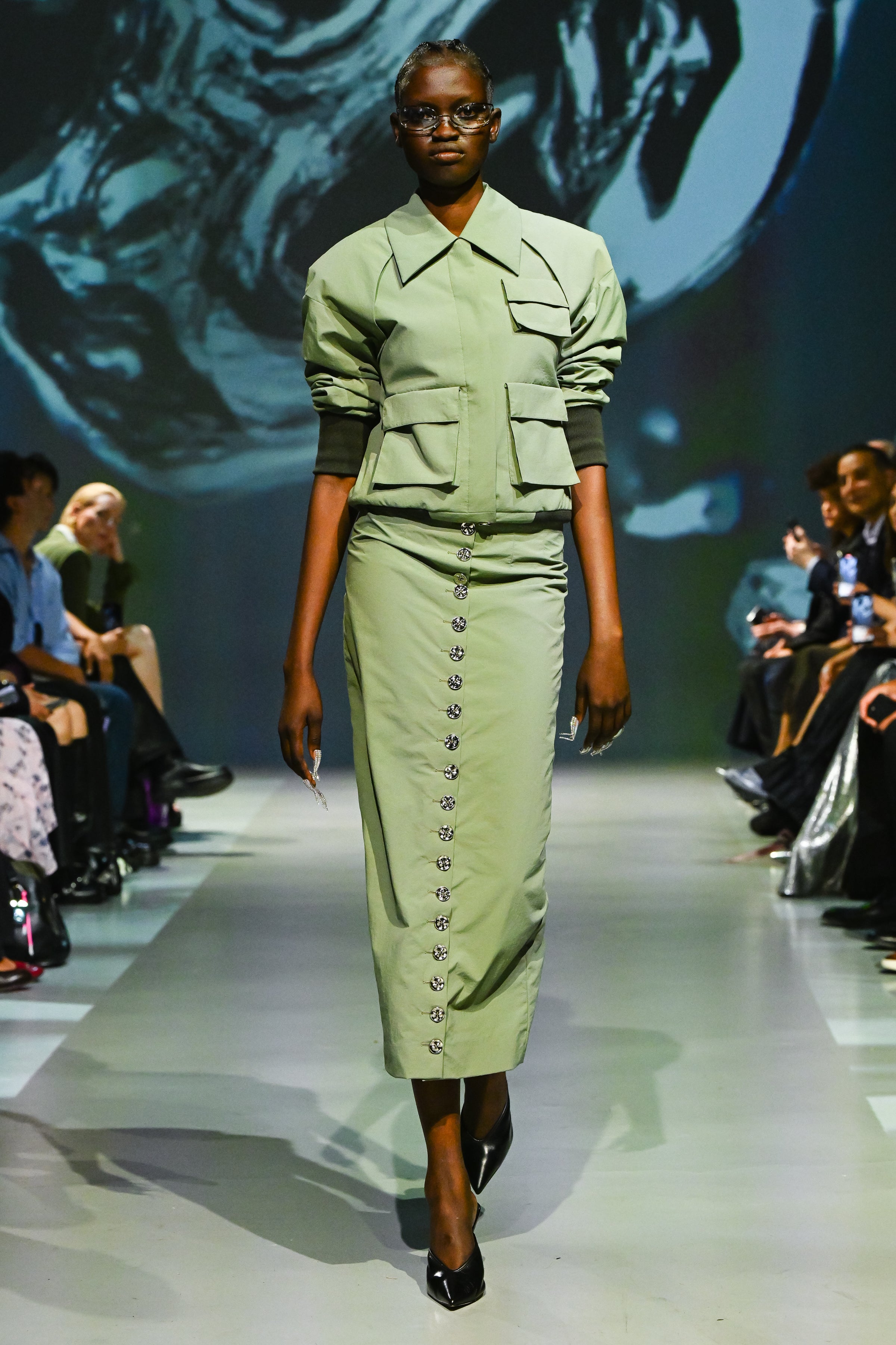 Sage green utility bomber jacket styled with tailored trousers
