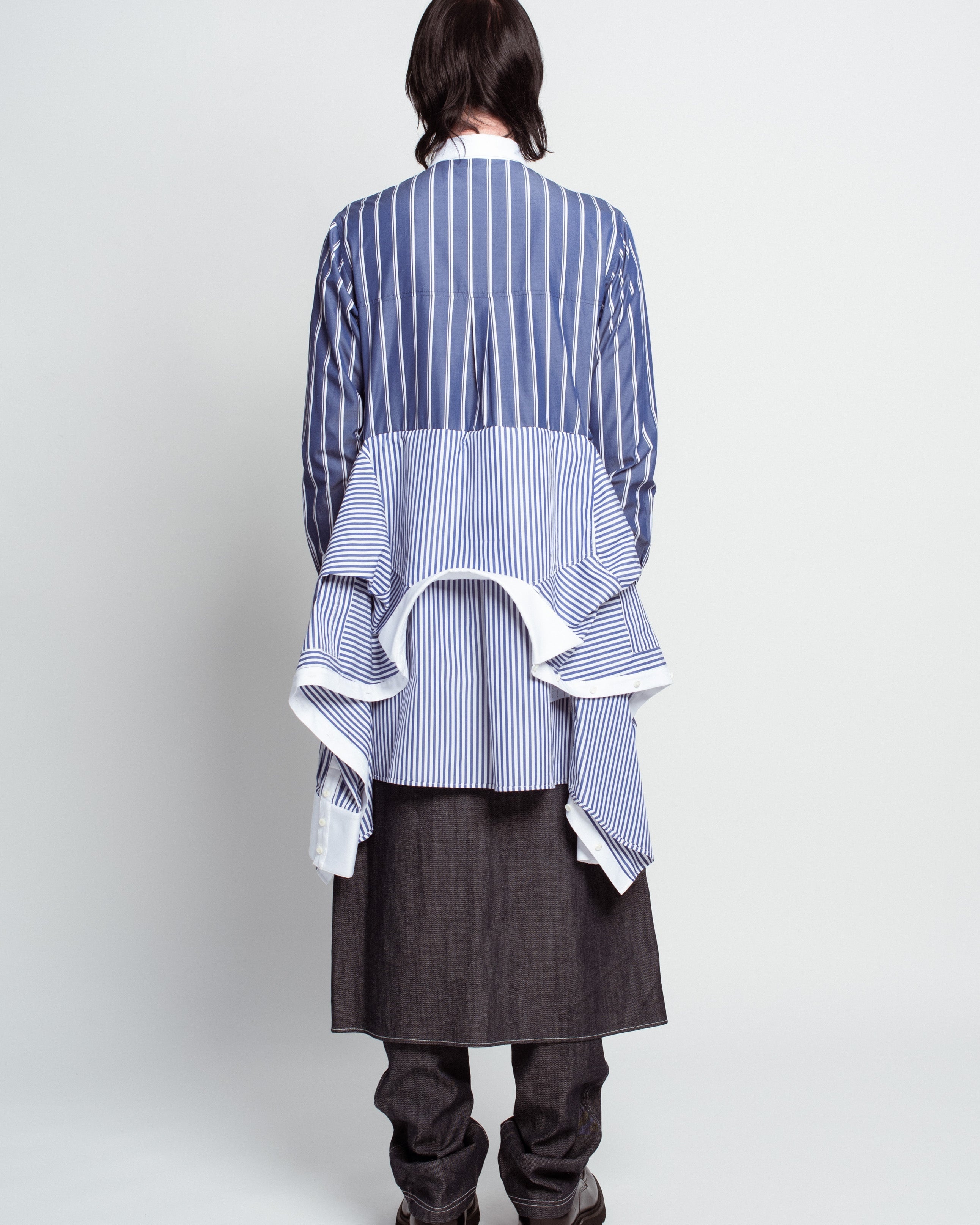 Back view of Blue Pinstripe Layered Shirt – Attached Back Construction with contrasting vertical stripes and sculptural layered draped detail, embodying SHAO New York bespoke tailoring and luxury designer fashion.