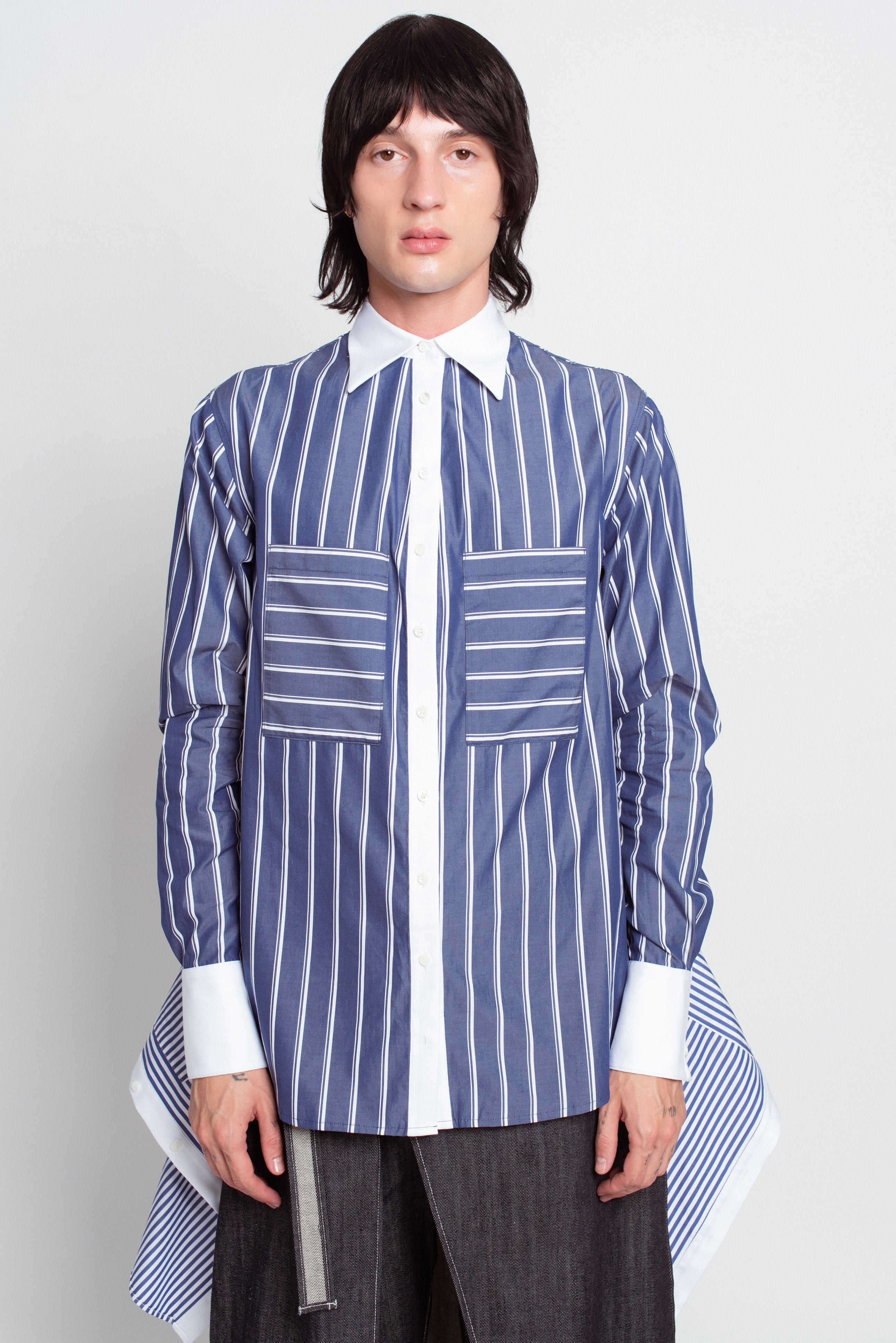 Front view of Blue Pinstripe Layered Shirt – Attached Back Construction in navy with vertical and horizontal white stripes, contrasted by crisp white collar and cuffs, featuring oversized patch pockets and layered detailing, showcasing SHAO New York bespoke tailoring and luxury designer fashion with a sculptural silhouette.