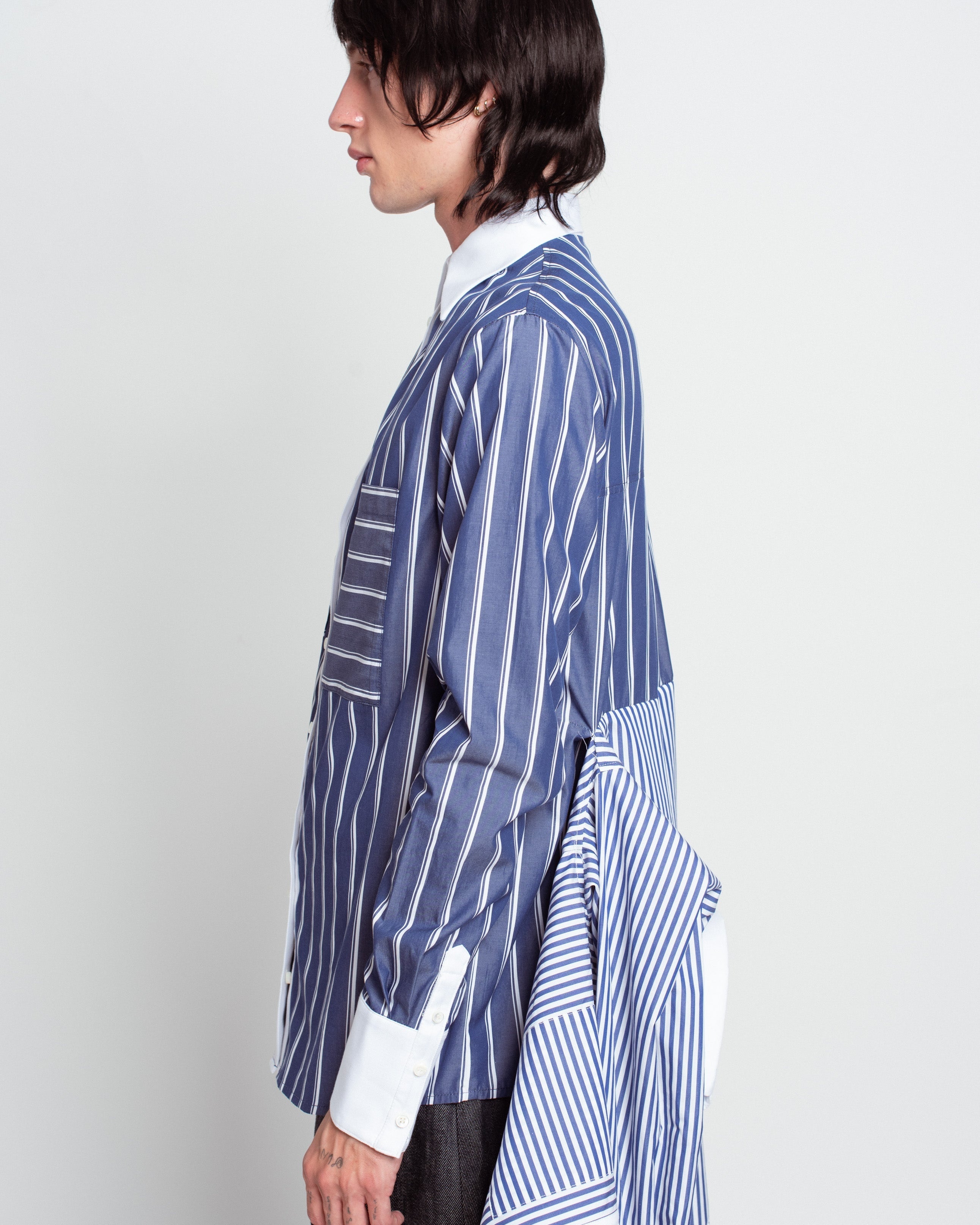 Side profile of Blue Pinstripe Layered Shirt – Attached Back Construction featuring mixed stripe patterns, crisp white collar and cuffs, and an innovative draped back detail showcasing SHAO New York bespoke tailoring and luxury designer fashion.