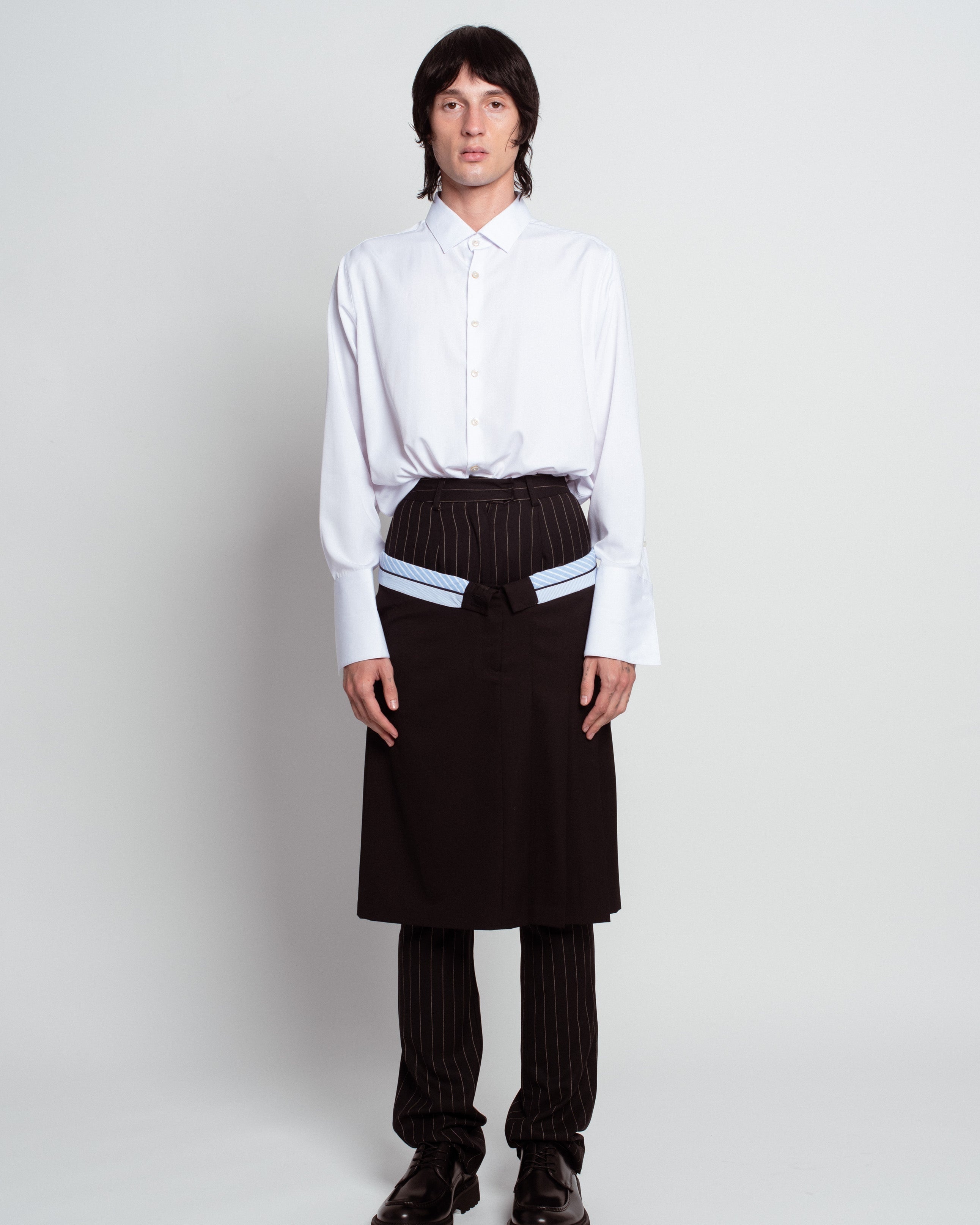 Front view of White Classic Button-Down Shirt with a relaxed fit, featuring extended cuffs and a clean collar, styled with layered tailored trousers showcasing SHAO New York bespoke tailoring and luxury designer fashion.