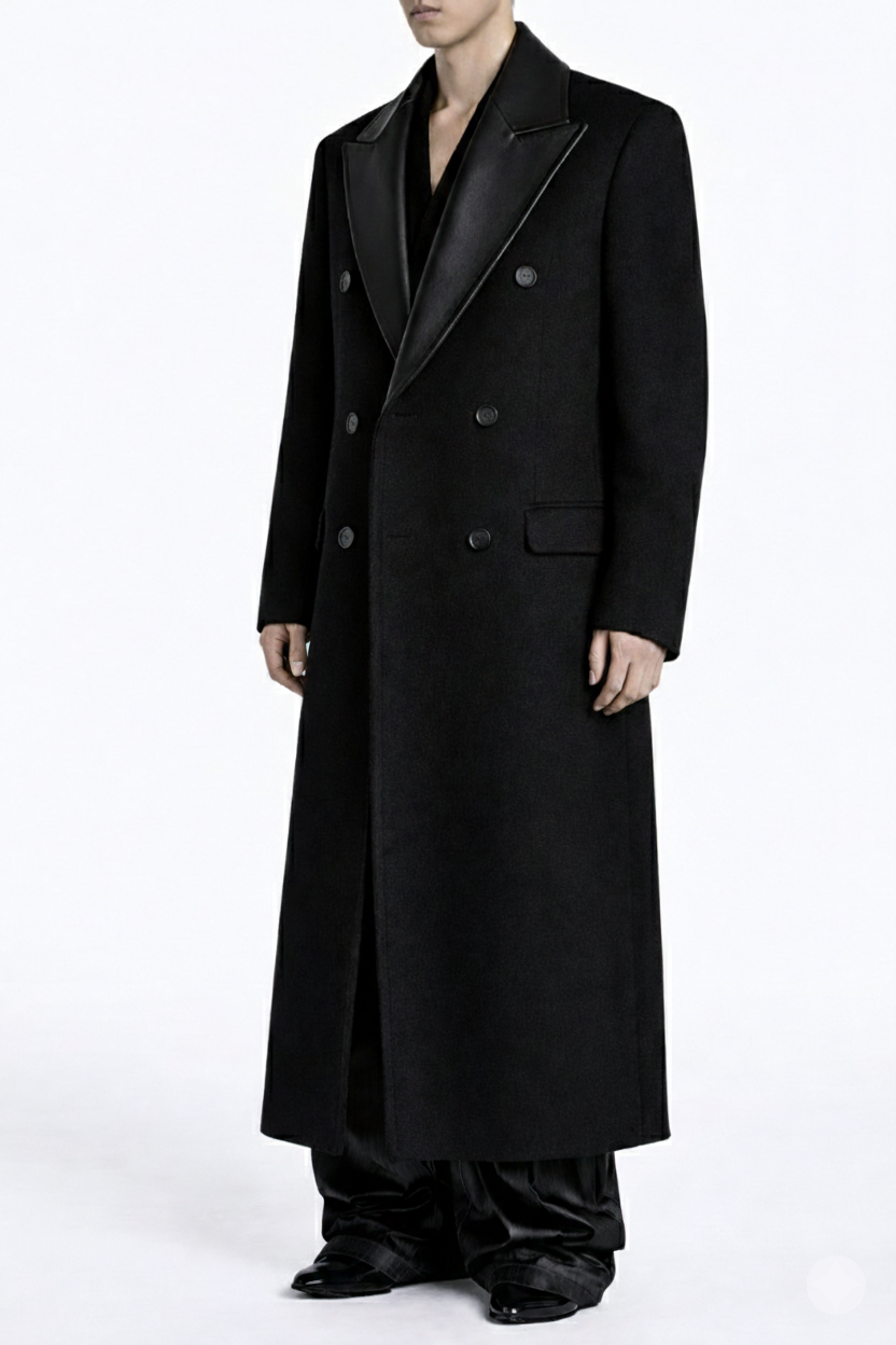 Model wearing an Oversized Black Cashmere Overcoat With Leather Accents featuring a double-breasted front, wide leather lapels, and a long sculptural silhouette reflecting New York designer tailoring.