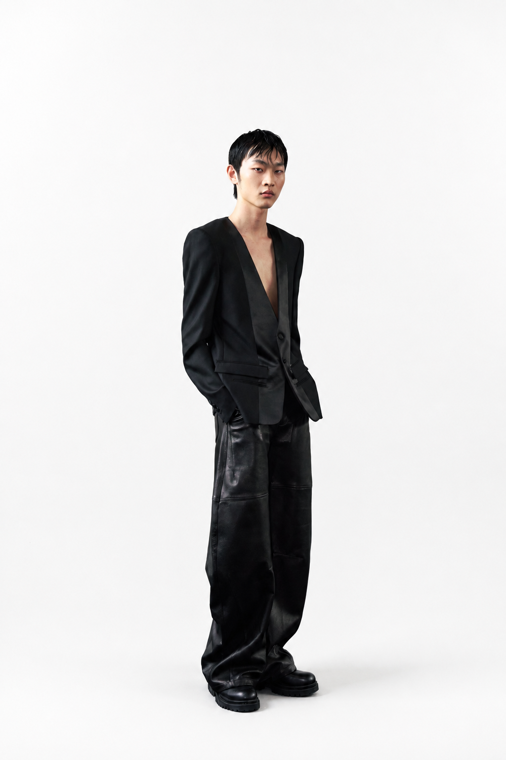 Model wearing Barrel Leg Leather Trousers styled with a deep V-neck black blazer and chunky black shoes, showcasing SHAO New York’s luxury bespoke tailoring and sculptural silhouette.