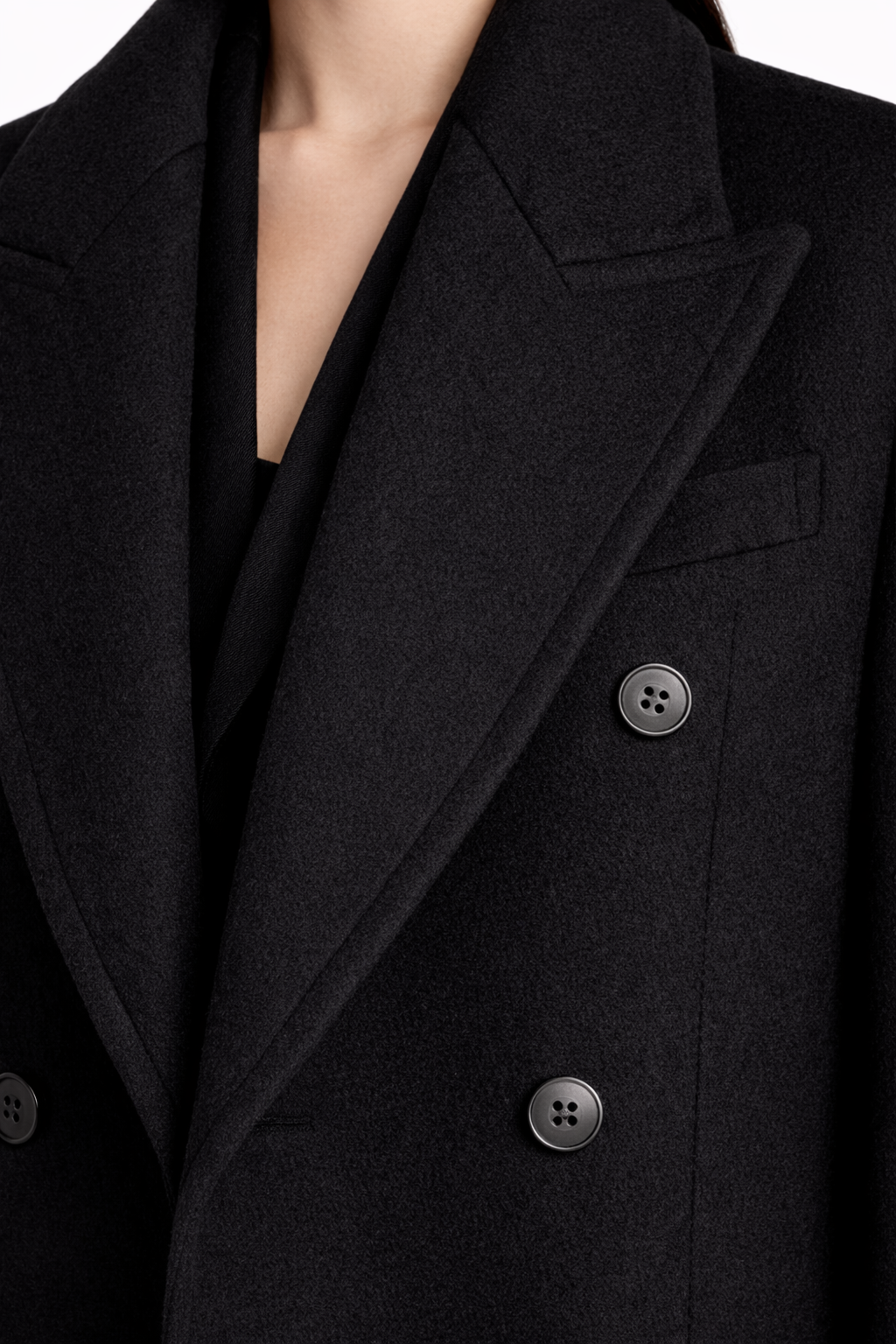 Close-up of the Oversized Black Cashmere Overcoat showcasing its luxe textured fabric, wide sculptural lapels, double-breasted button details, and refined bespoke tailoring by SHAO New York.