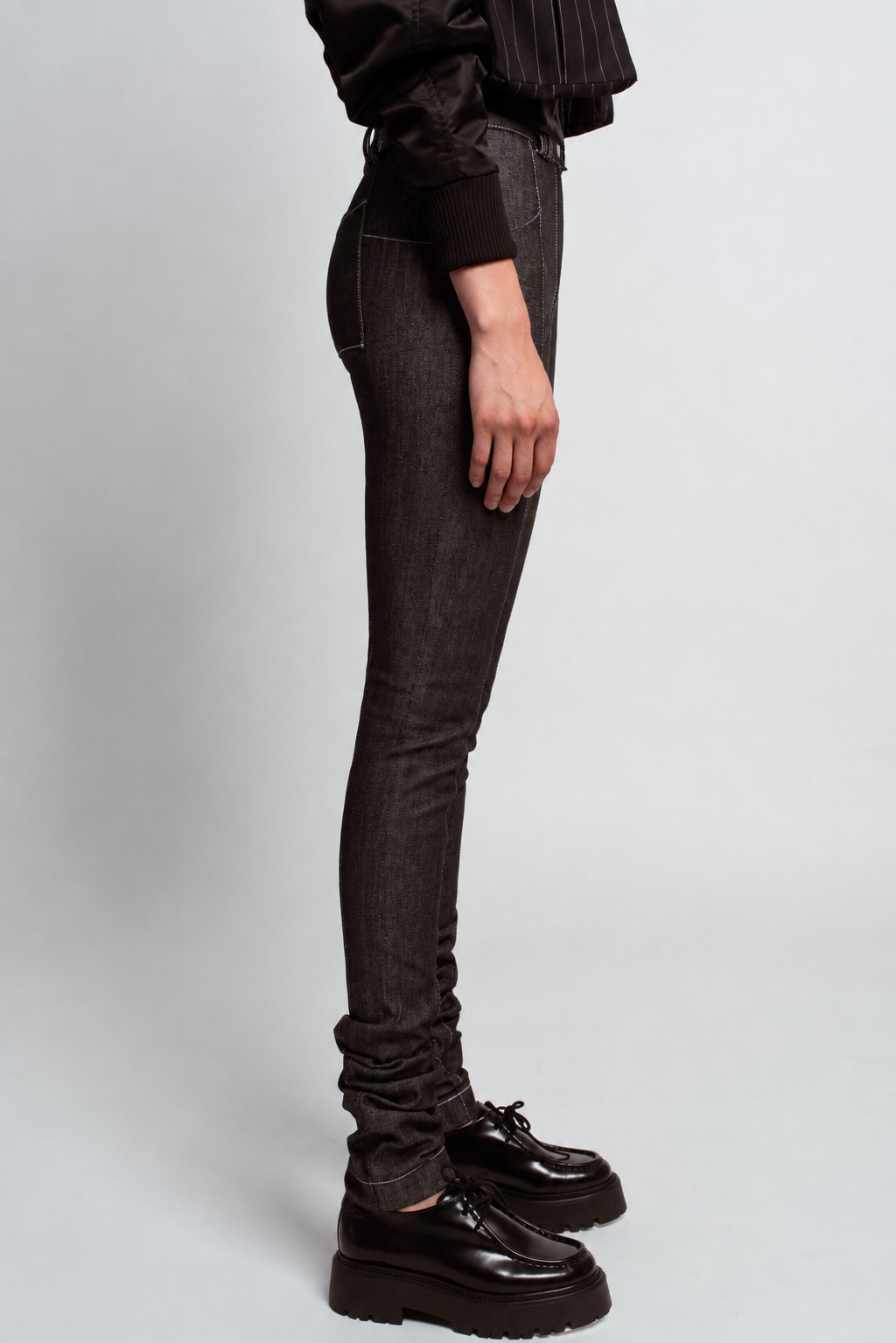 Side view of SHAO Belt Loop Skinny Jeans in deep charcoal denim, featuring a high-rise fit, tailored silhouette with subtle ruching at the ankle, exemplifying bespoke New York designer tailoring.