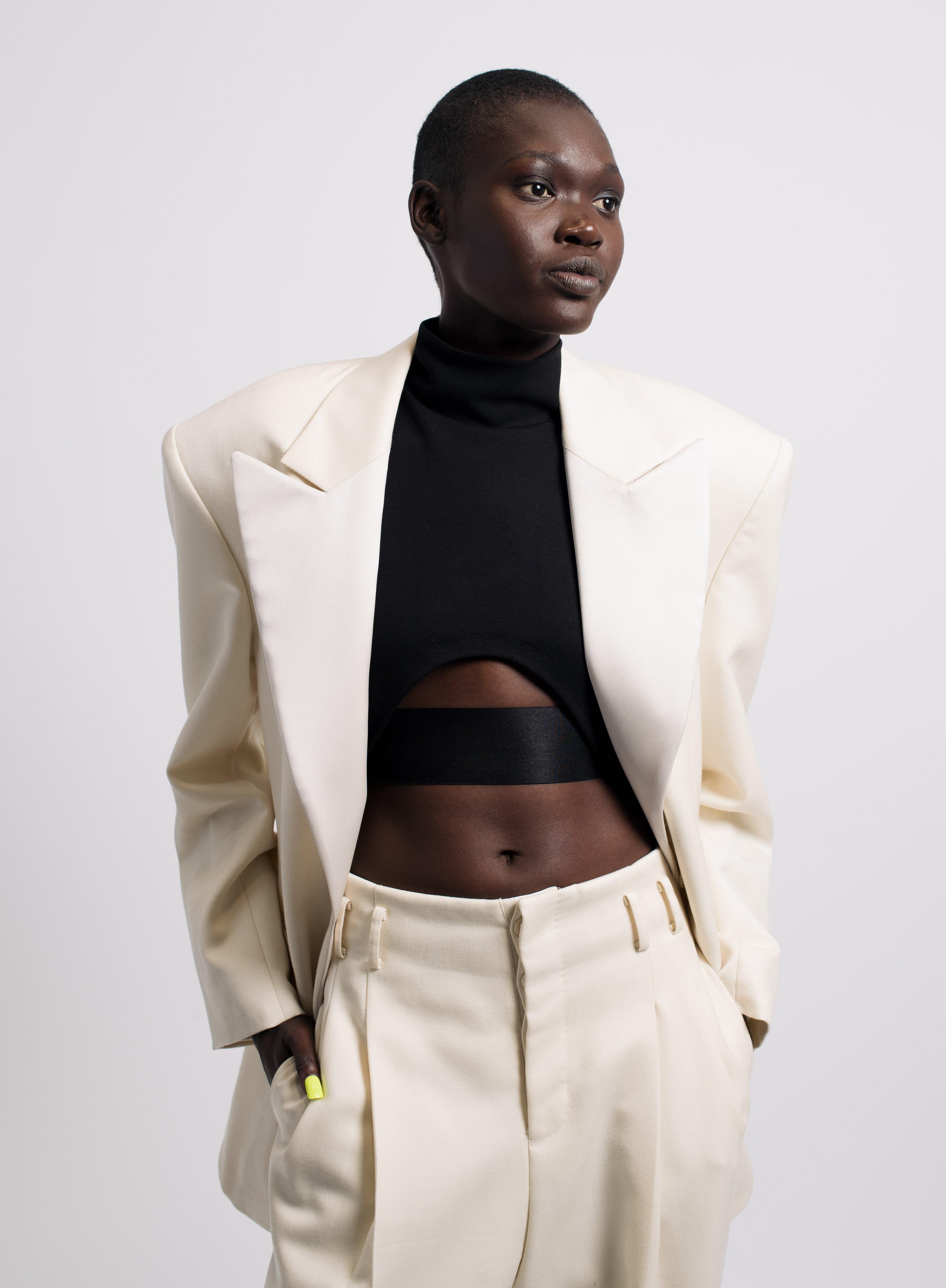 Model wearing Cream Satin-Lapelled Single-Button Tuxedo Jacket styled with matching high-waisted trousers and a black cropped turtleneck, highlighting SHAO New York bespoke tailoring and a modern sculptural silhouette.