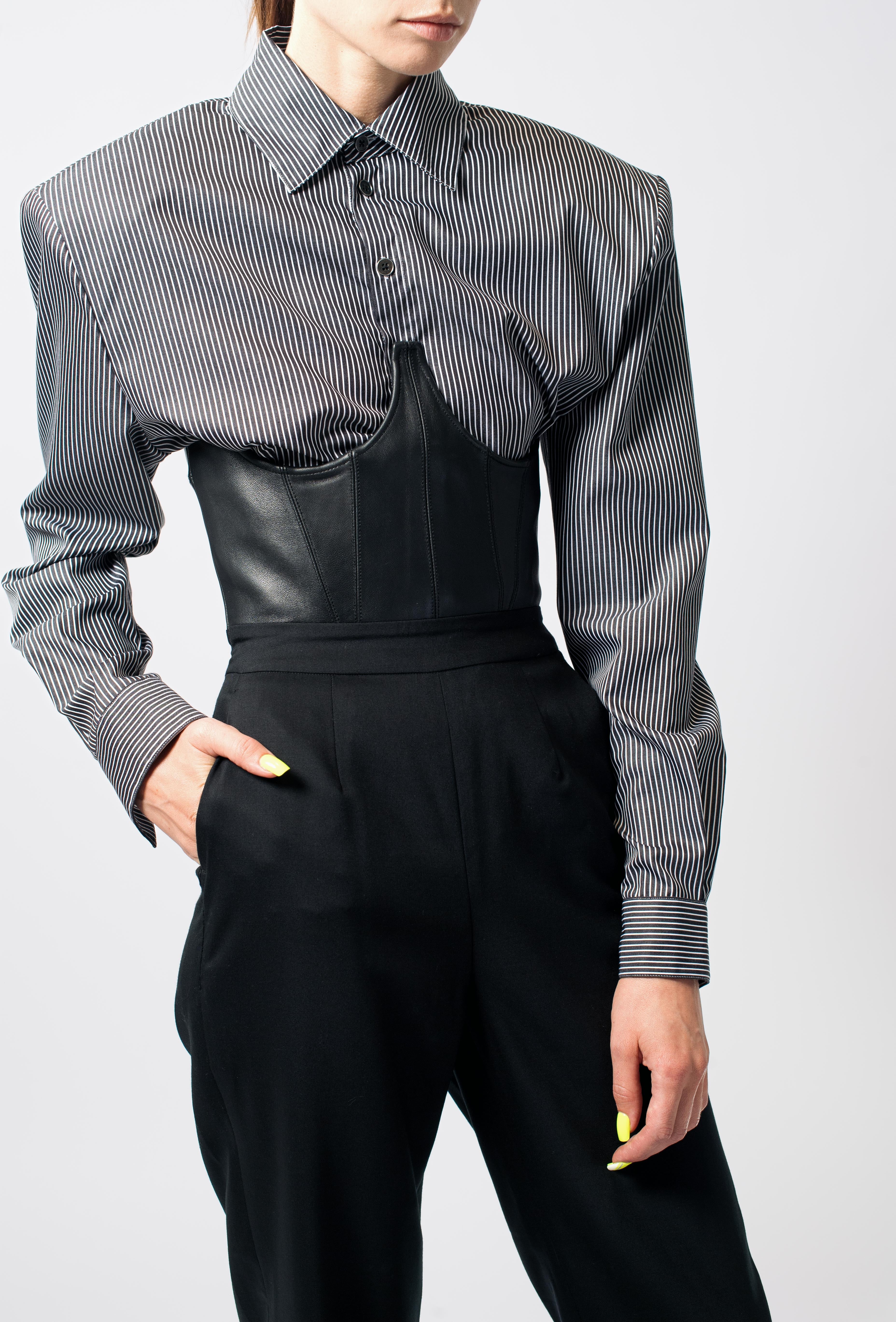 Gray Pinstripe Balloon-Sleeve Shirt showcasing sharp tailored shoulders, slim sleeves, and classic collar, styled with a black leather corset and high-waisted trousers for a sculptural silhouette.
