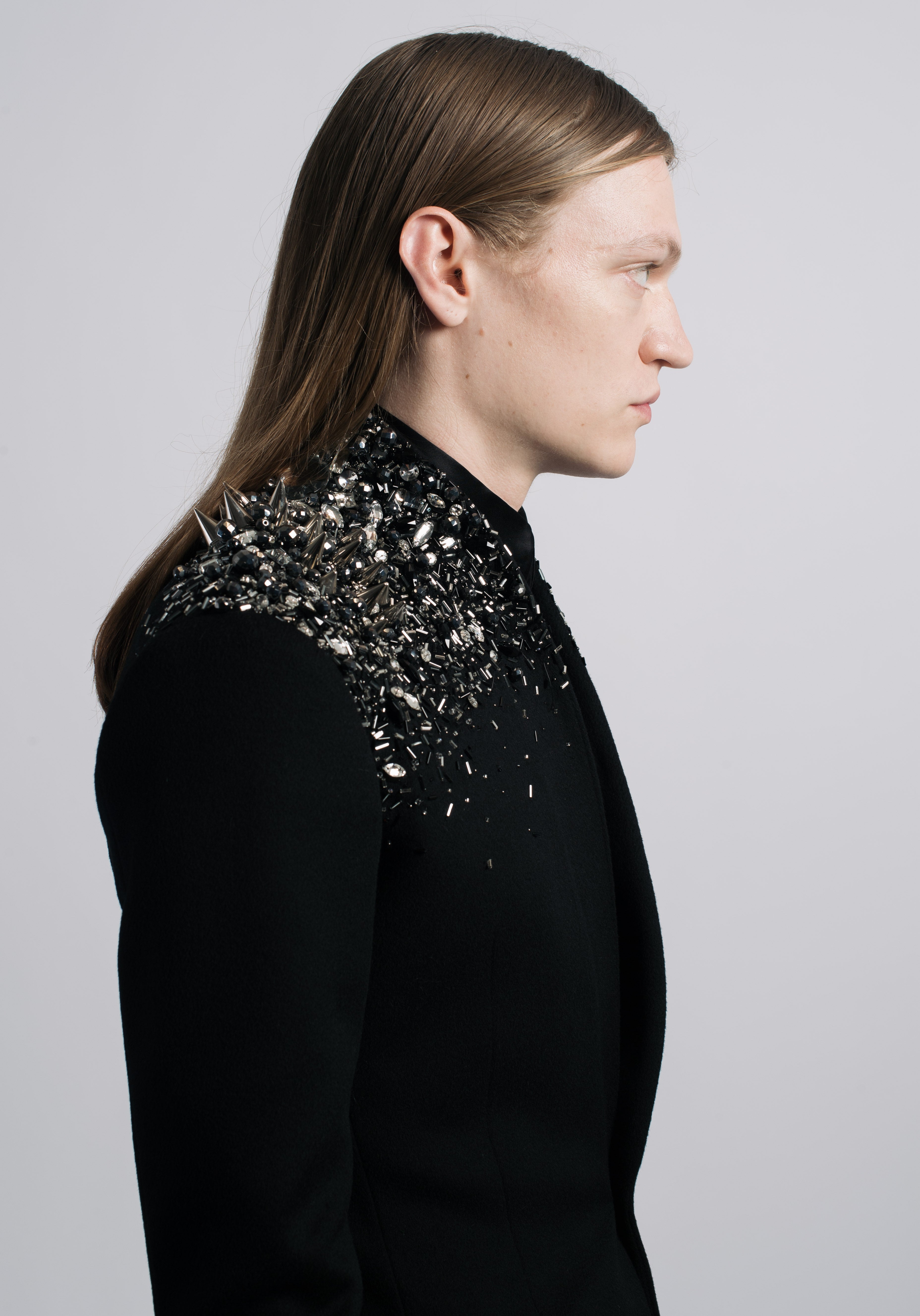 Black Crystal-Embellished Wool Blazer showcasing a sharp tailored fit with a dramatic cluster of dark crystals and metal spikes on the shoulder, reflecting SHAO New York bespoke tailoring and a contemporary sculptural silhouette.