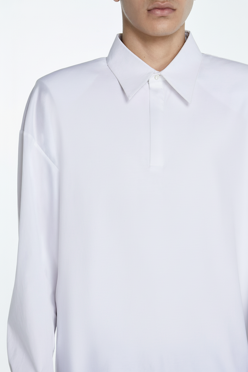 Close-up front view of Architectural White Polo Shirt featuring a minimalist pointed collar, hidden placket, dropped shoulders, and clean lines reflecting luxury bespoke tailoring by SHAO New York.