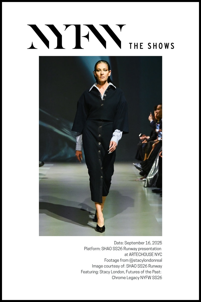 Stacy London, wearing a navy button-down dress and a blue collared shirt underneath, walks the runway.