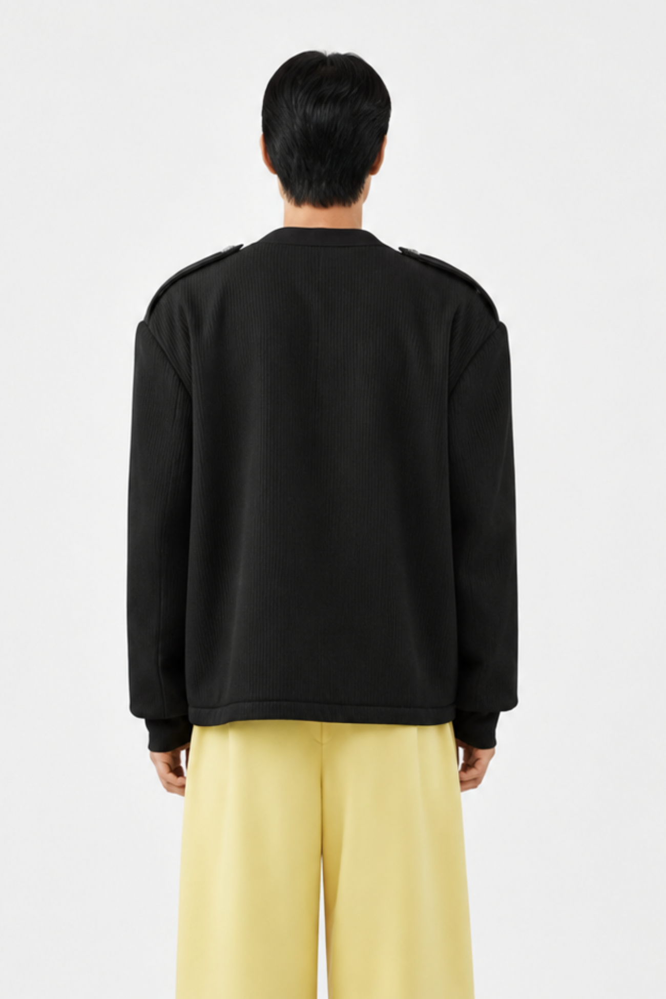 Back view of Black Military-Style Utility Cardigan featuring a relaxed fit, structured shoulders with epaulets, and subtle ribbed texture, highlighting bespoke tailoring and luxury designer fashion.