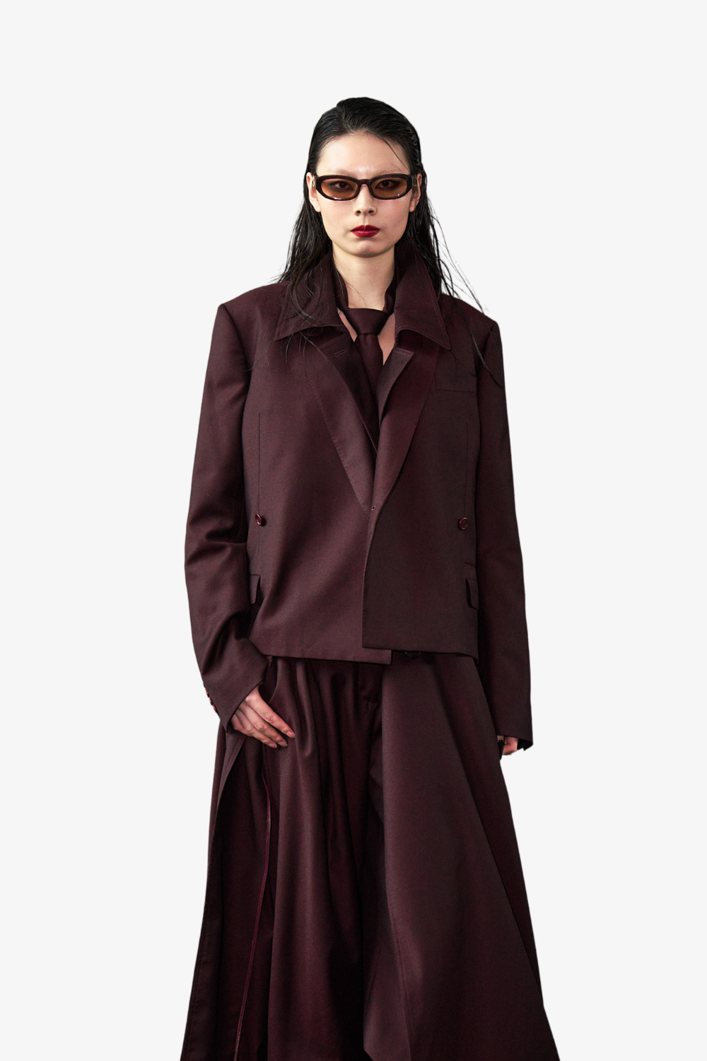 Model wearing a rich plum tailored jacket and flowing skirt paired with a Wool Tie 7.5 cm in matching deep plum, styled with sleek hair and modern tinted sunglasses, embodying SHAO New York’s luxury bespoke tailoring and sculptural silhouette.