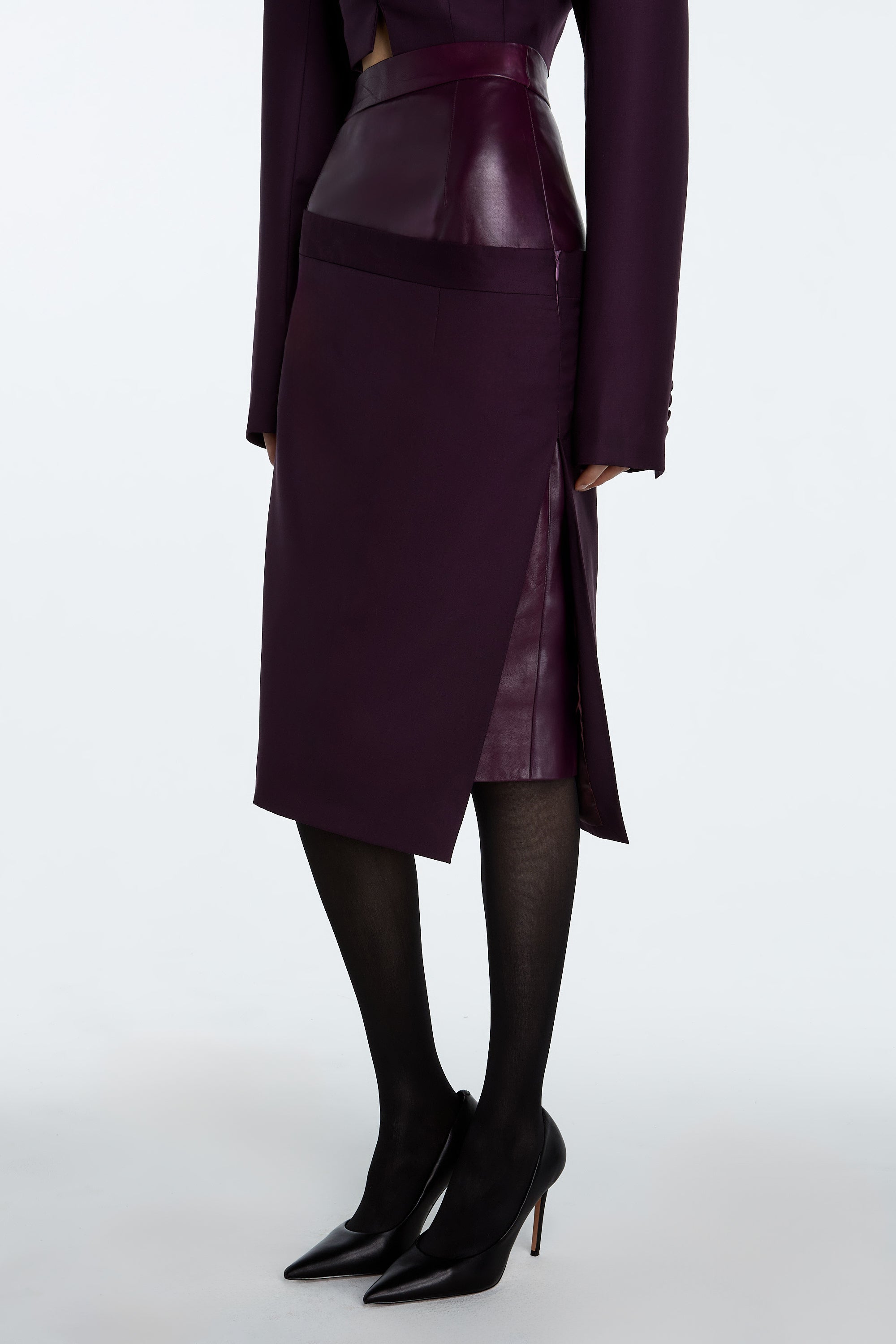 Aubergine Dual-Layer Asymmetrical Draped Skirt with leather and wool layers in rich aubergine tone, knee-length.