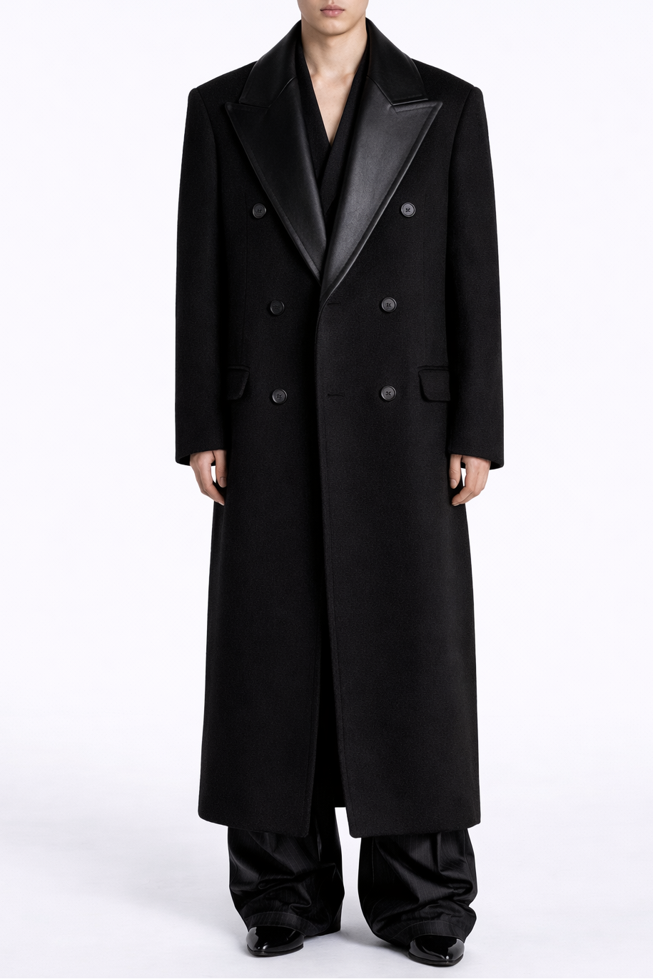 Person wearing a long black coat on a white background