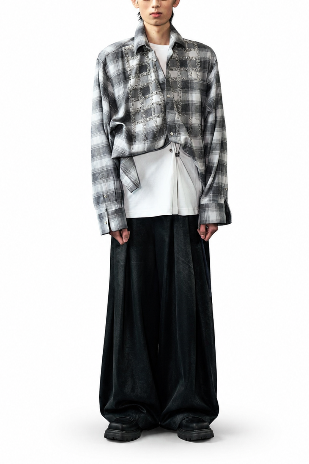 Model wearing Box-Pleated All Over Coated Denim Jeans in a deep black finish with a wide-leg design, paired with layered casual tops and chunky black footwear, showcasing a sculptural silhouette in SHAO New York luxury designer fashion.