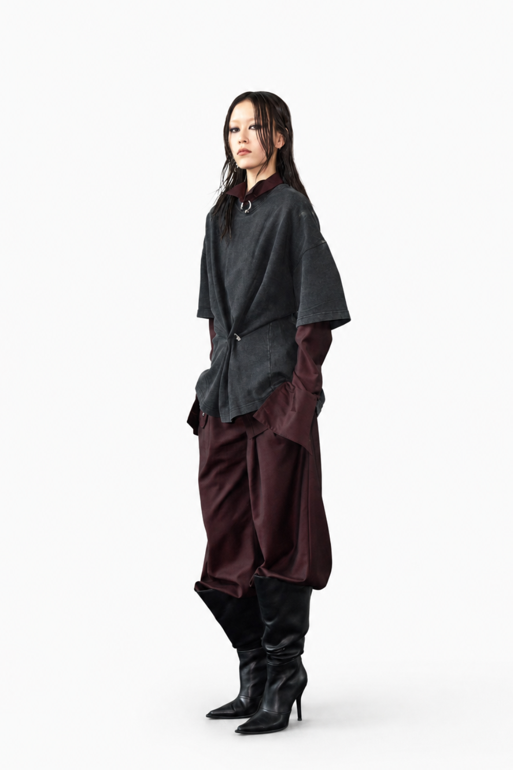 Model dressed in burgundy Wool Barrel Pleated Trousers - Burgundy paired with layered dark tops and black heeled boots, embodying a sculptural silhouette with SHAO New York bespoke tailoring influences.
