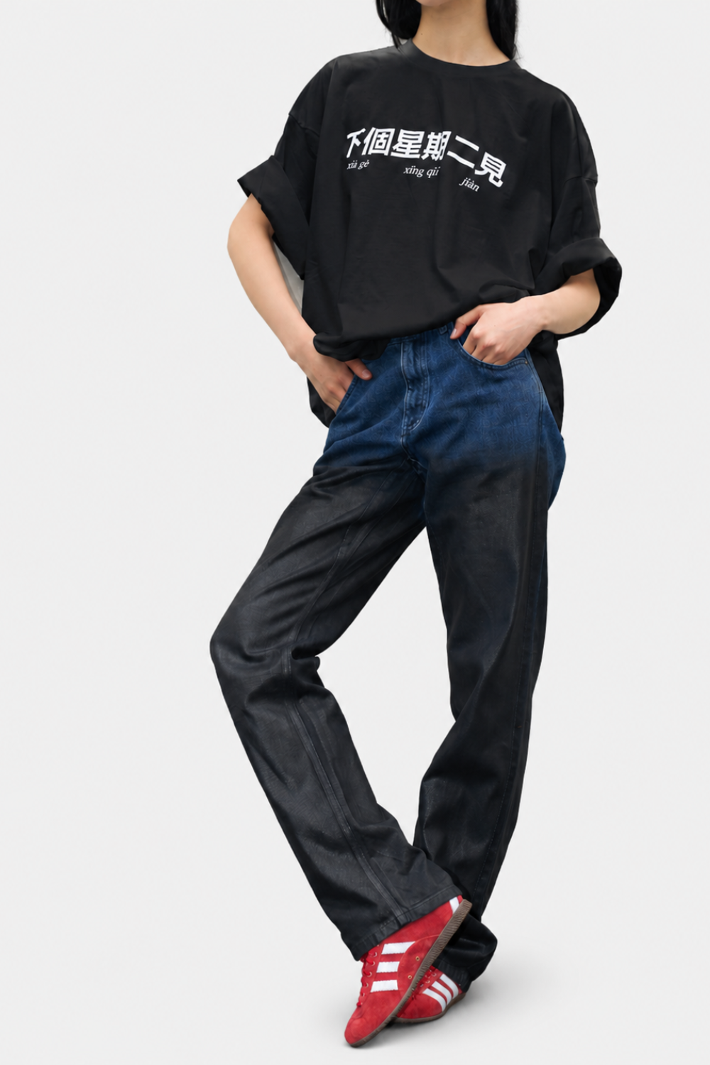 Model wearing the See you next Tuesday Graphic Shirt in black with white Chinese characters and phonetic script, styled with rolled sleeves for a relaxed urban look.