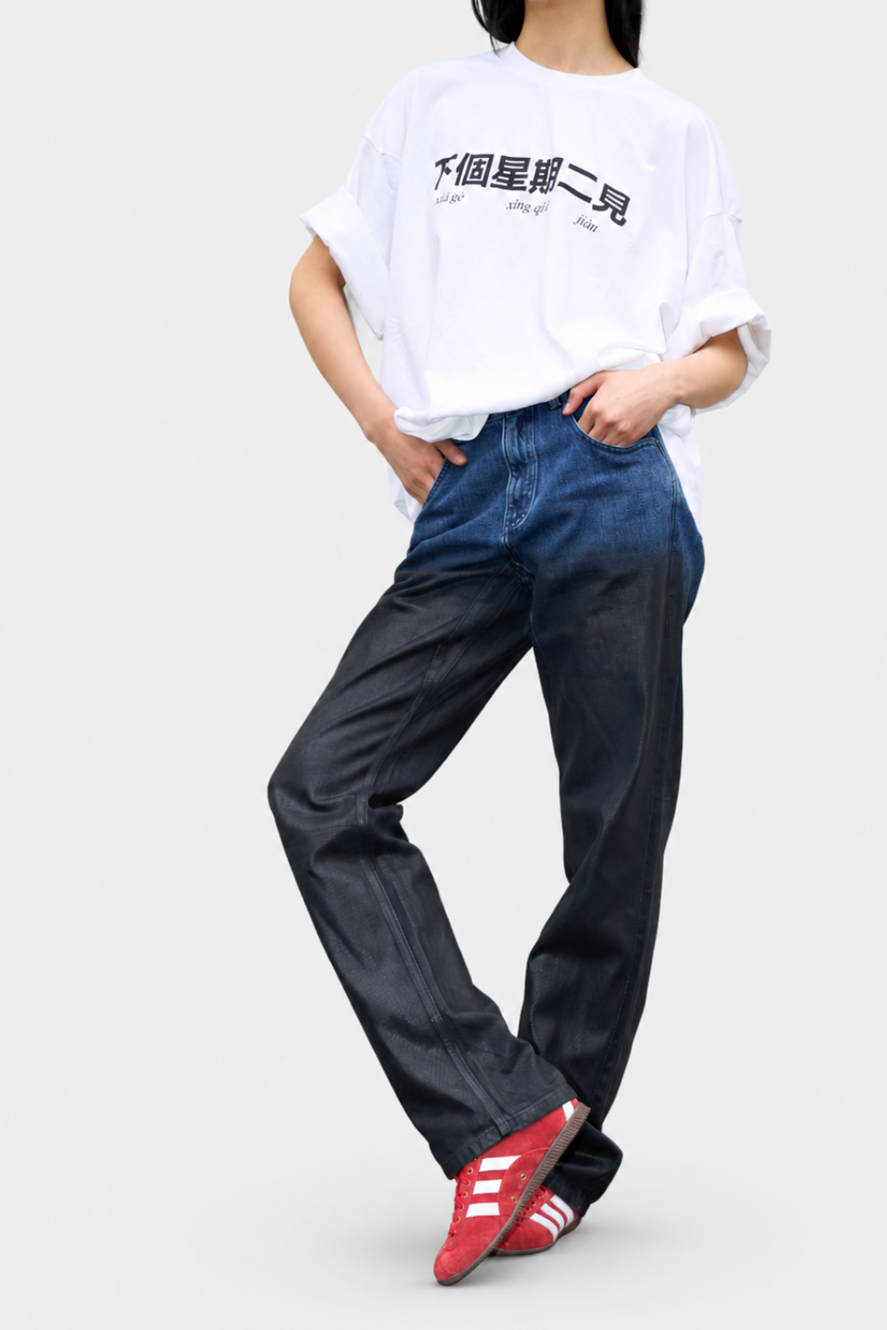Model wearing the See you next Tuesday Graphic Shirt in soft white fabric with black Chinese characters and phonetic script, styled casually with rolled sleeves and relaxed fit.