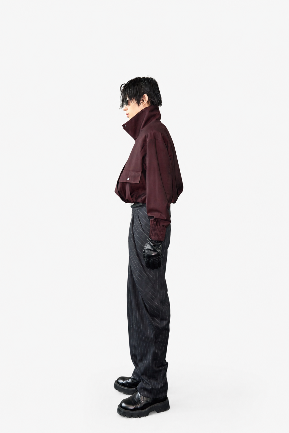Model wearing Tailored Wool Balloon Bomber Jacket - Burgundy with a high collar and voluminous sleeves, paired with pinstriped trousers and black leather gloves, showcasing SHAO New York bespoke tailoring and a sculptural silhouette.