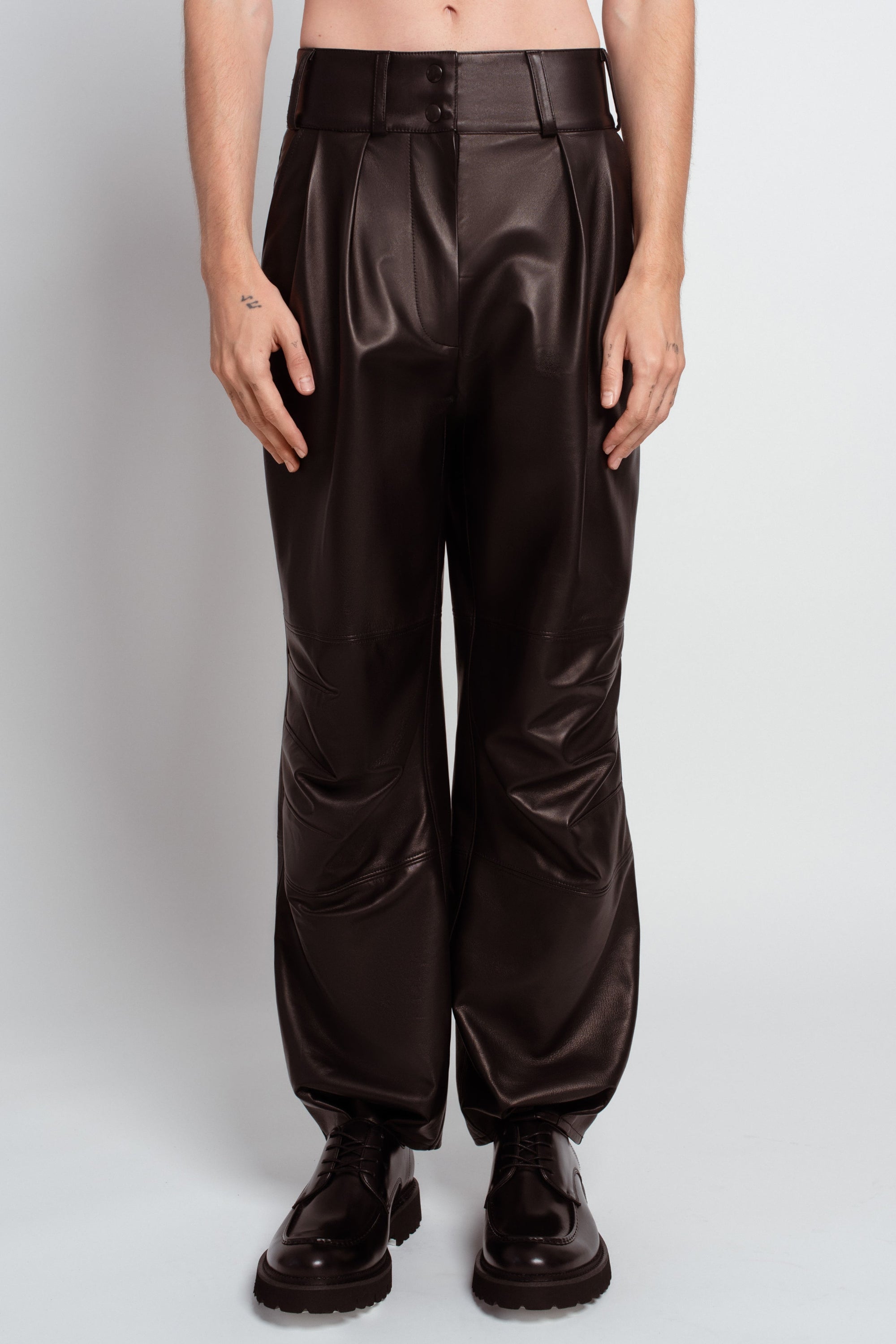 Jet black leather pleated trousers architectural front view