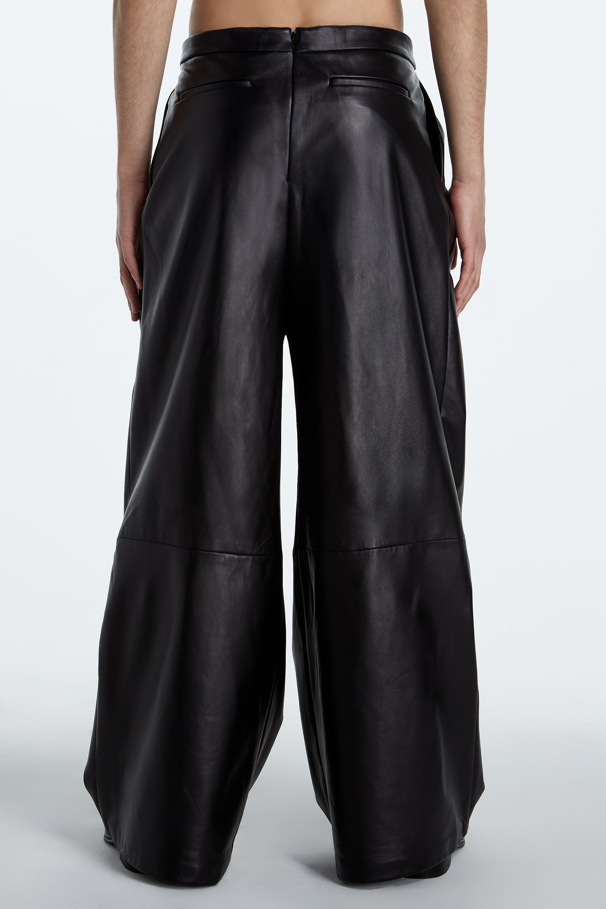 SHAO jet black leather asymmetrical pleated trousers back view